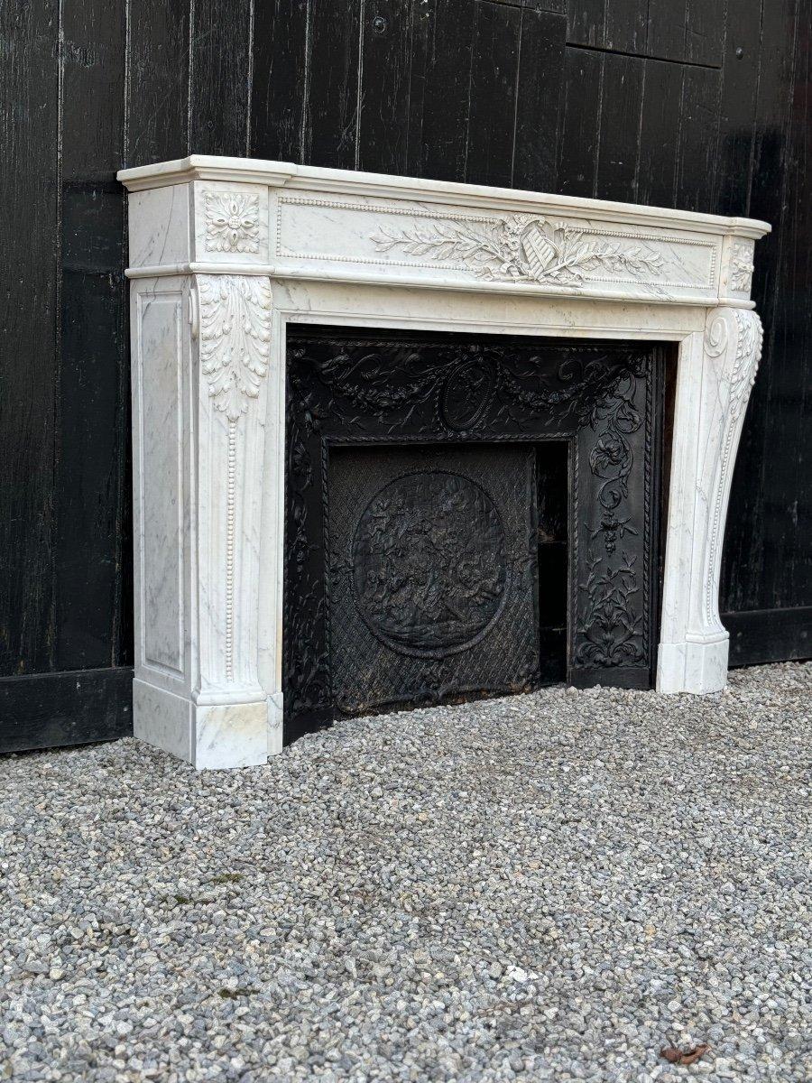 Louis XVI style fireplace in white Carrara marble circa 1880  with cast iron interior

Dimensions of the cast iron hearth: 66 x 74.5 cm 

Marble fireplace hearth dimensions: 90 x 118.5cm