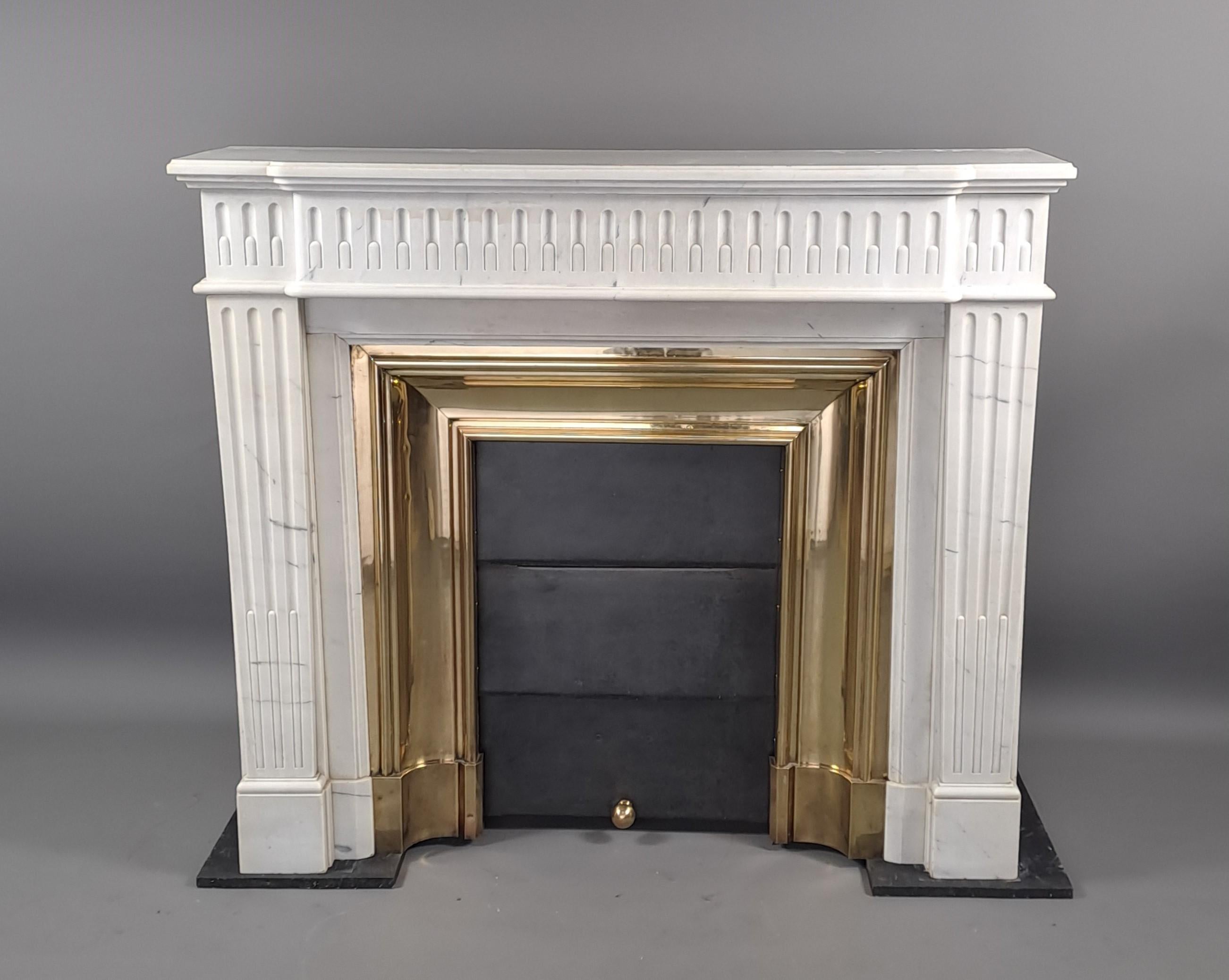 Magnificent Louis XVI style fireplace in white Carrara marble with a raised front decorated with generous rudentée fluting.   

With its polished brass narrowing as well as its sliding shutter door (weight system to adjust the height).   

French