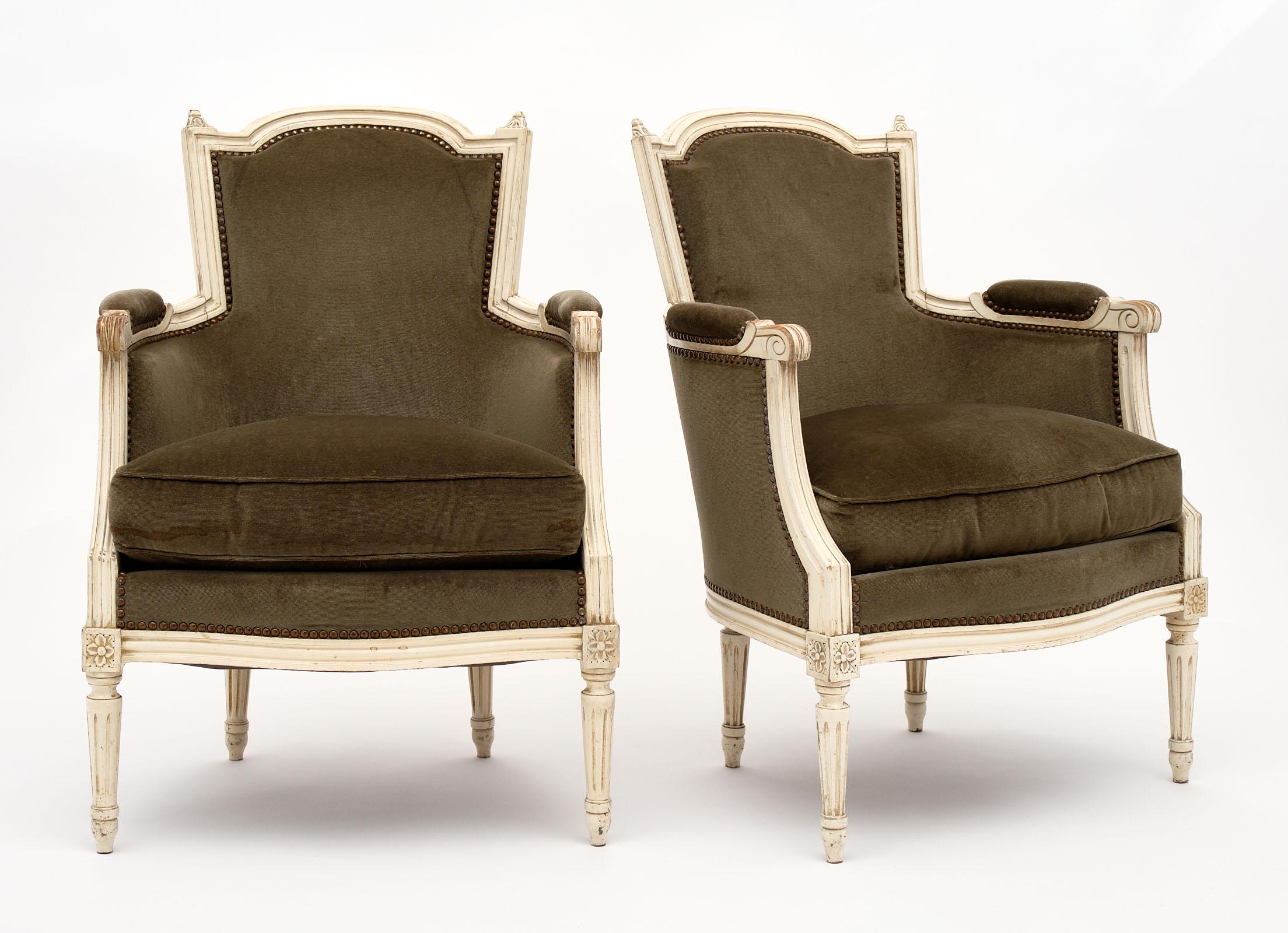 Louis XVI style French antique bergères with hand-painted beech wood frames and original velvet upholstery in good condition. They are quite sturdy and add a beautiful, Classic element to any space. We love the green hue of the fabric as well.