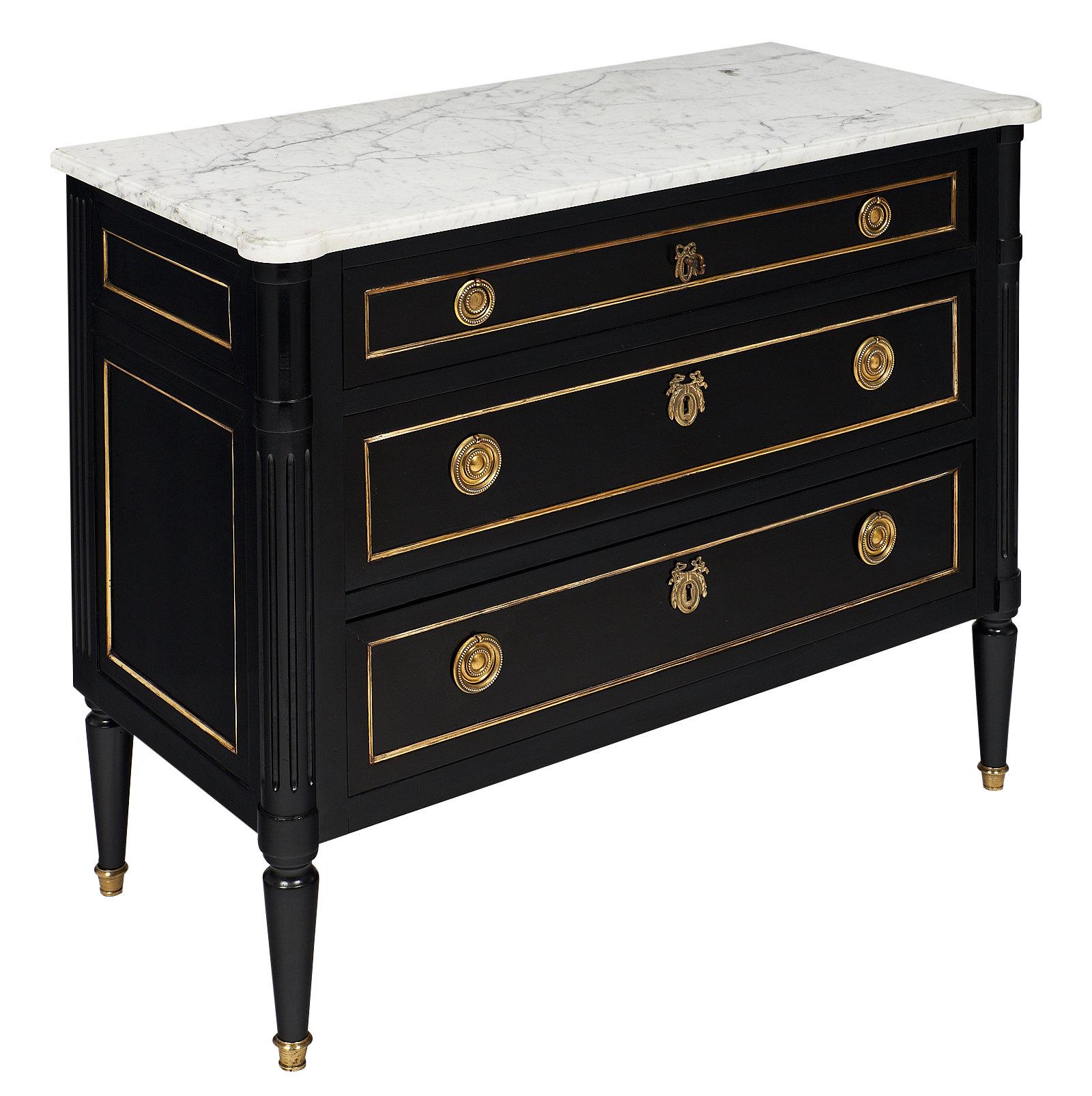 French Louis XVI style chest of drawers of mahogany, ebonized and finished with a lustrous French polish. This elegant “commode” features its original Carrara marble top, gilded brass hardware and trim.