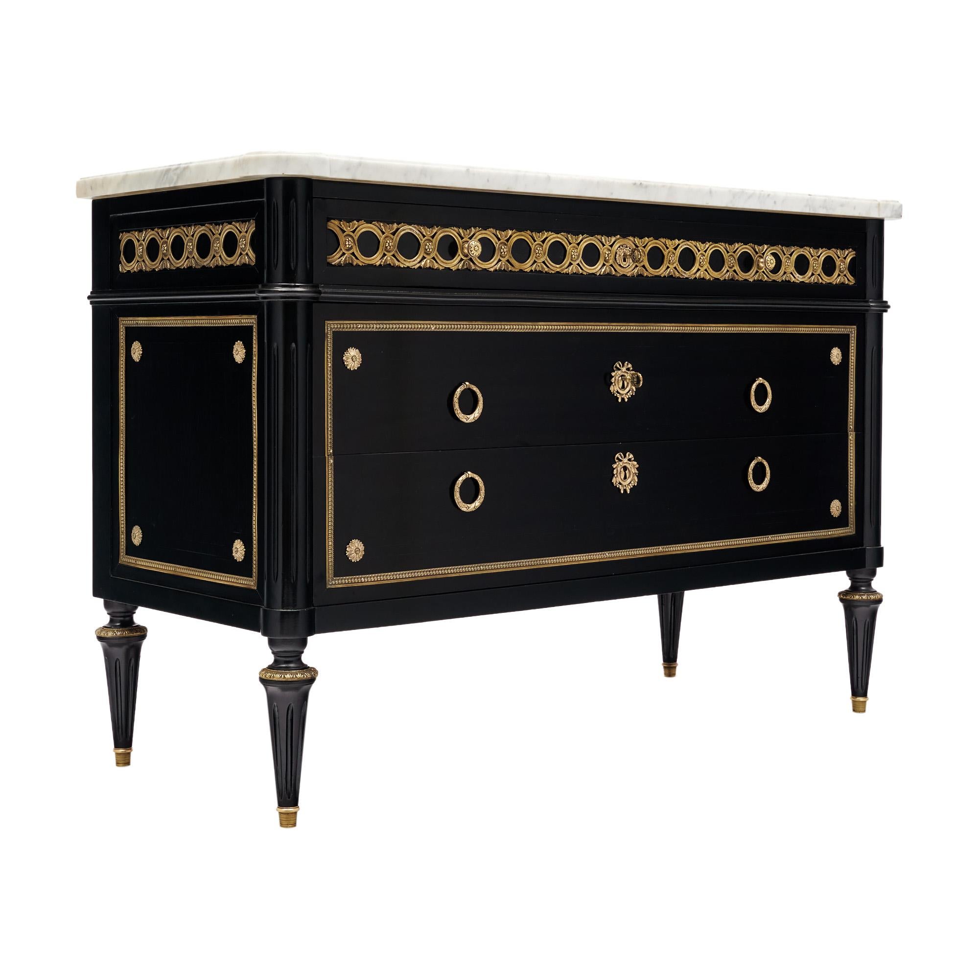 Chest of drawers in the Louis XVI style from France. This piece is made of solid wood construction, primarily mahogany. It has been ebonized and finished with a lustrous museum-quality French polish with gilded ormulu throughout. Three dovetailed