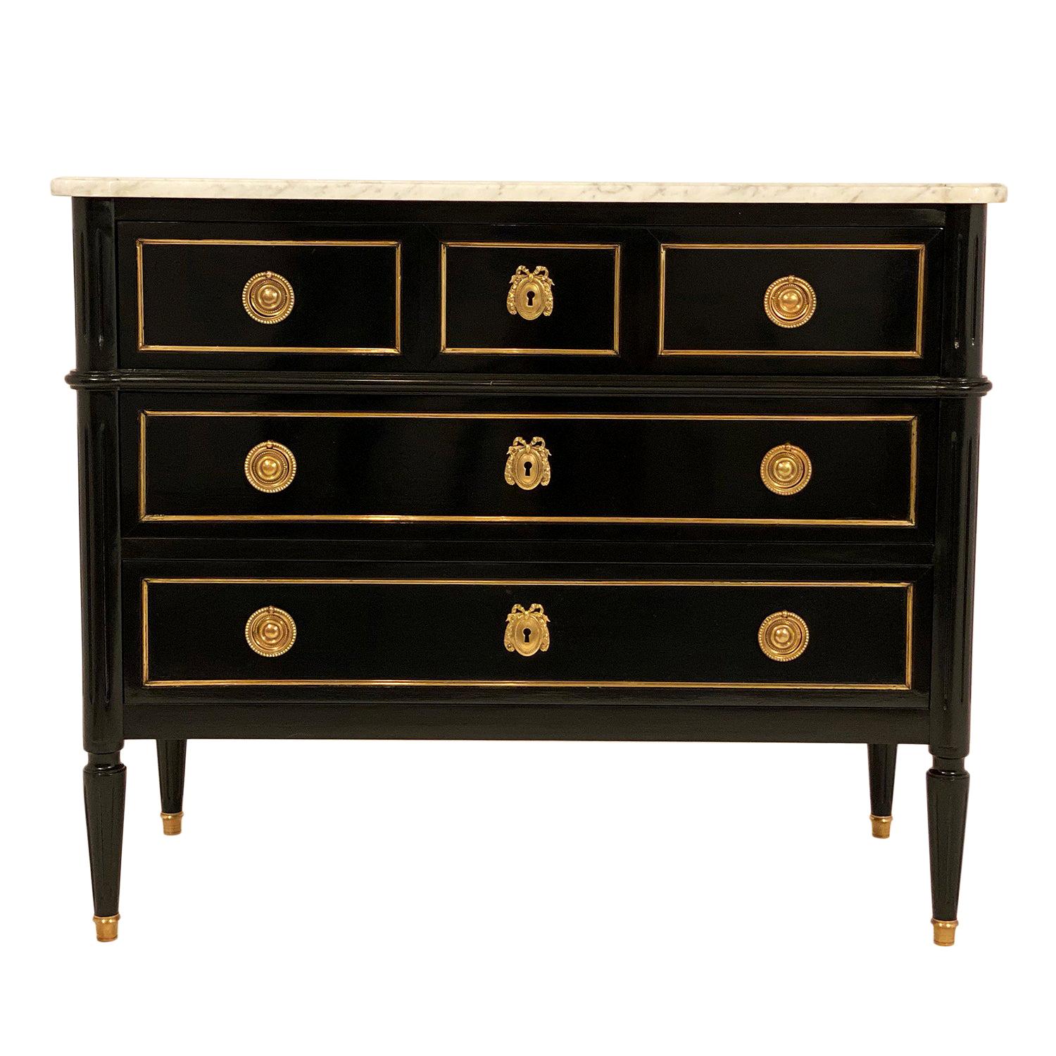 Louis XVI style French chest of drawers made of mahogany that has been ebonized and finished with a lustrous museum quality French polish. Three dovetailed drawers are embellished with finely cast gilt bronze hardware and brass trim throughout. The
