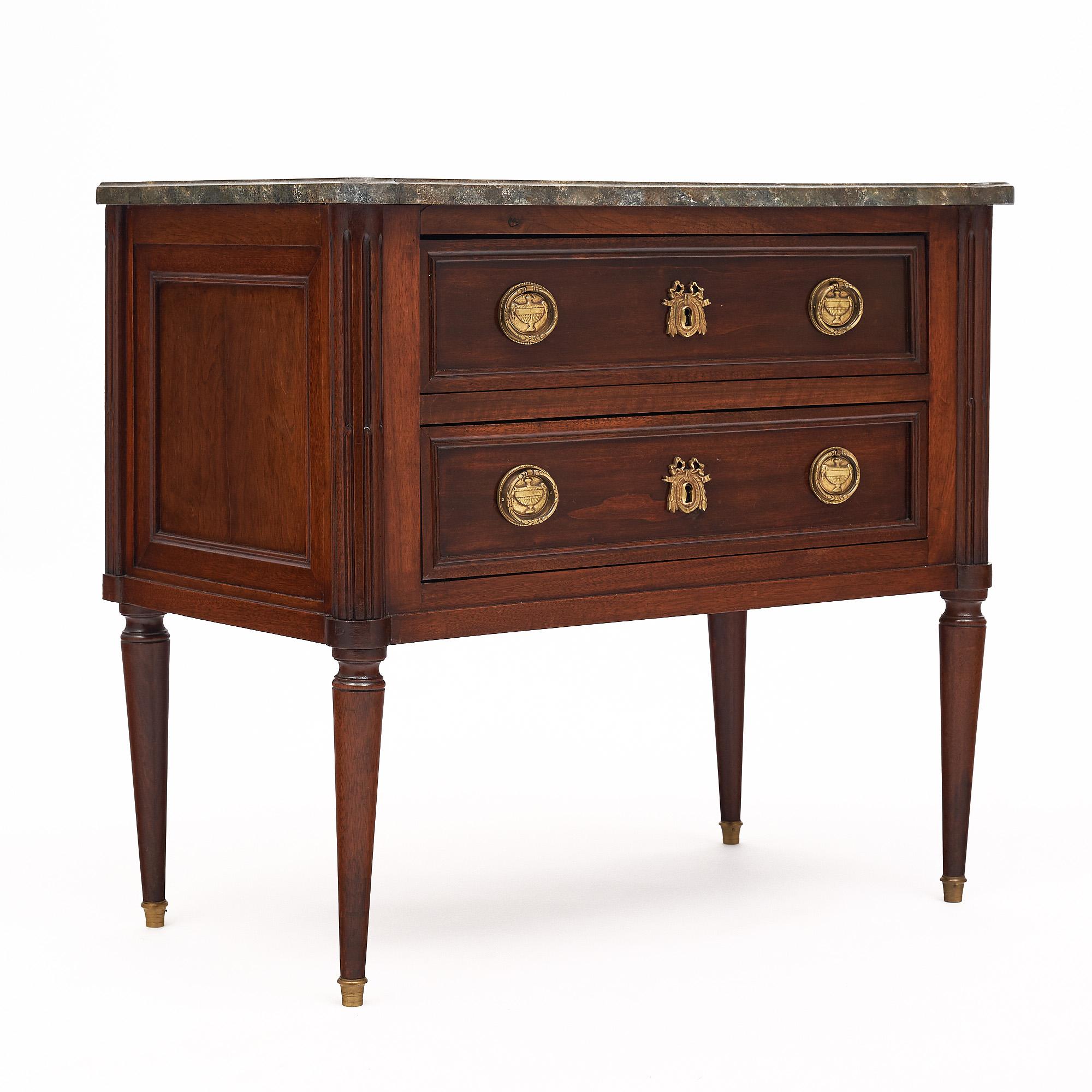 Chest of drawers from France in the Louis XVI style. This piece is made of mahogany that has been finished with a lustrous French polish of museum quality. There are two dovetailed drawers each featuring finely cast original brass hardware. The four