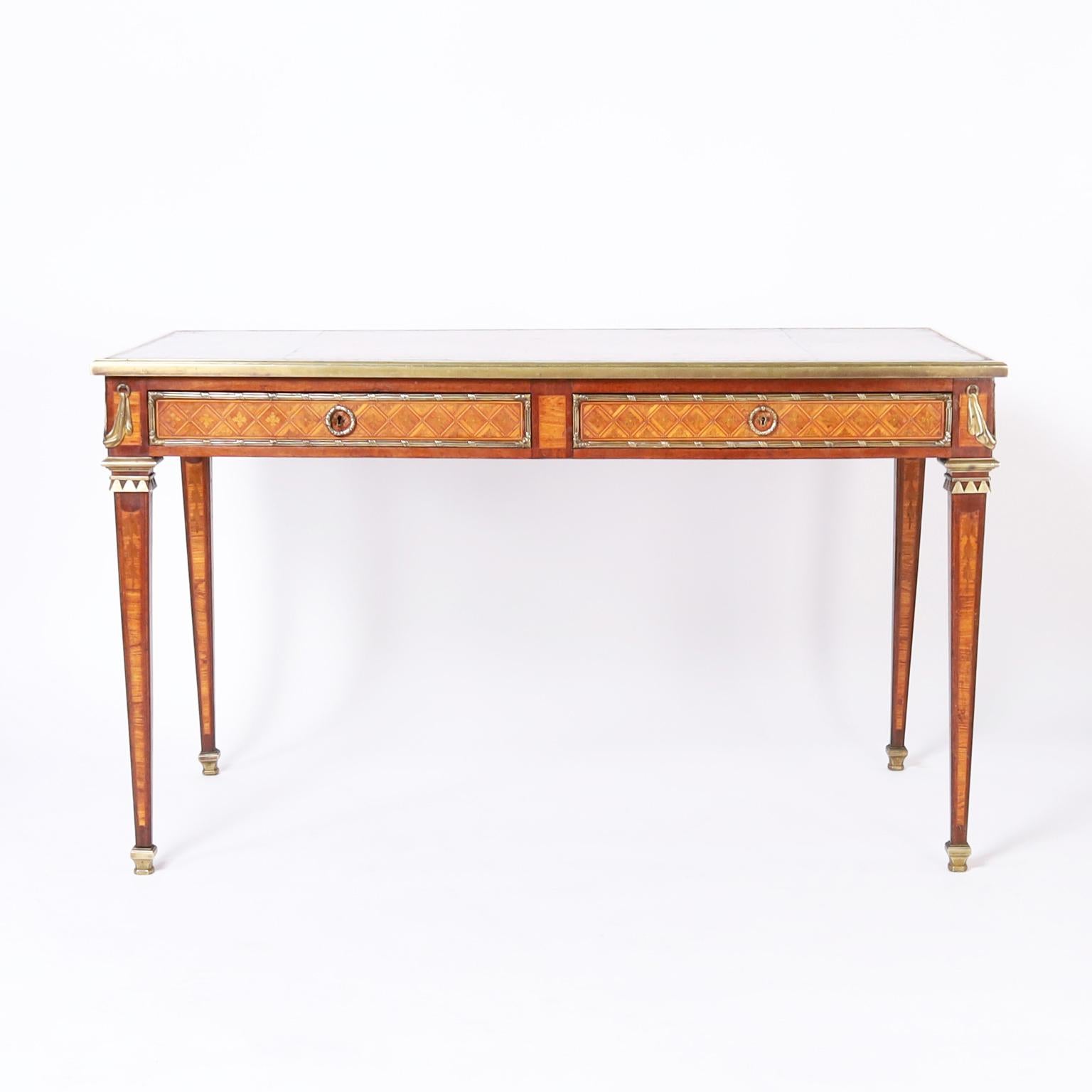 Impressive 19th century French desk with the original tooled leather top now aged to perfection over a two drawer case decorated with bronze ormolu and inlaid marquetry on elegant tapered legs with satinwood inlays on bronze feet. 