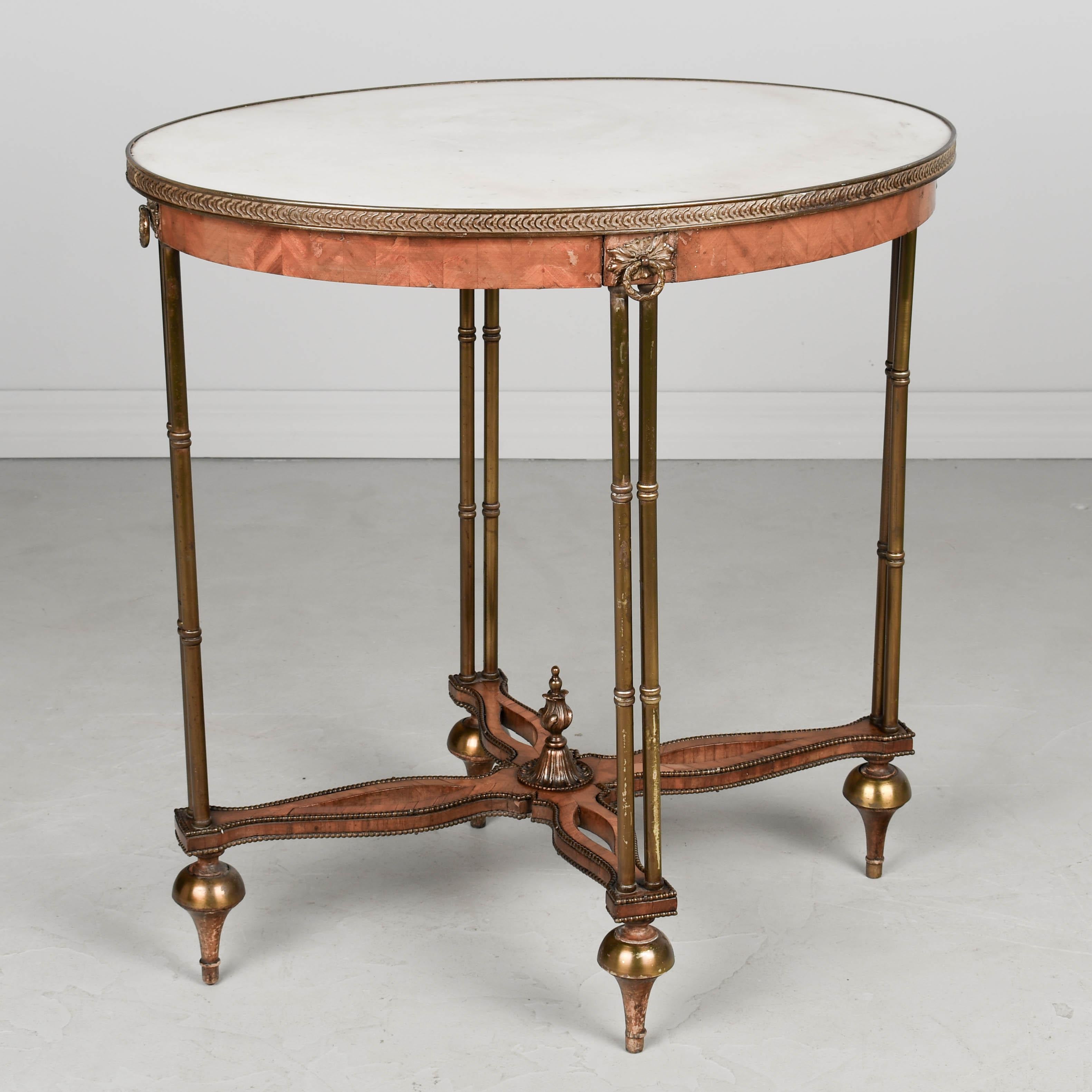 Table d'appoint ovale de style Louis XVI en placage d'érable avec plateau en onyx blanc. Les pieds en laiton sont reliés par un châssis décoratif découpé avec des clous en laiton, un épi de faîtage en laiton moulé et des sabots. Une table élégante