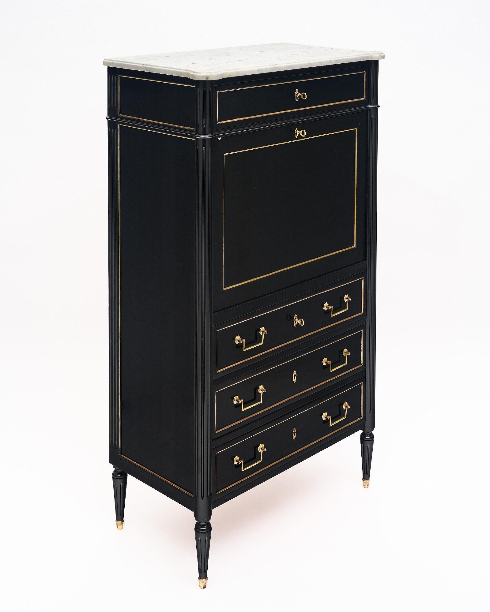 Secretary, drop front desk, French, in the Louis XVI style. This cabinet is finished in a lustrous museum quality ebonized French polish. There are four exterior dovetailed drawers with gilt brass trim and hardware throughout. The drop front is