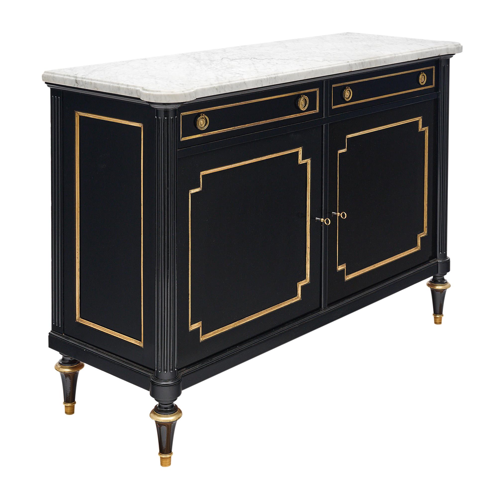 Buffet, French, in the Louis XVI style, of Mahogany, ebonized and finished in a lustrous Museum quality French polish, gilt brass throughout. Two dovetailed drawers and two doors opening to adjustable shelving, intact Carrara marble slab. The