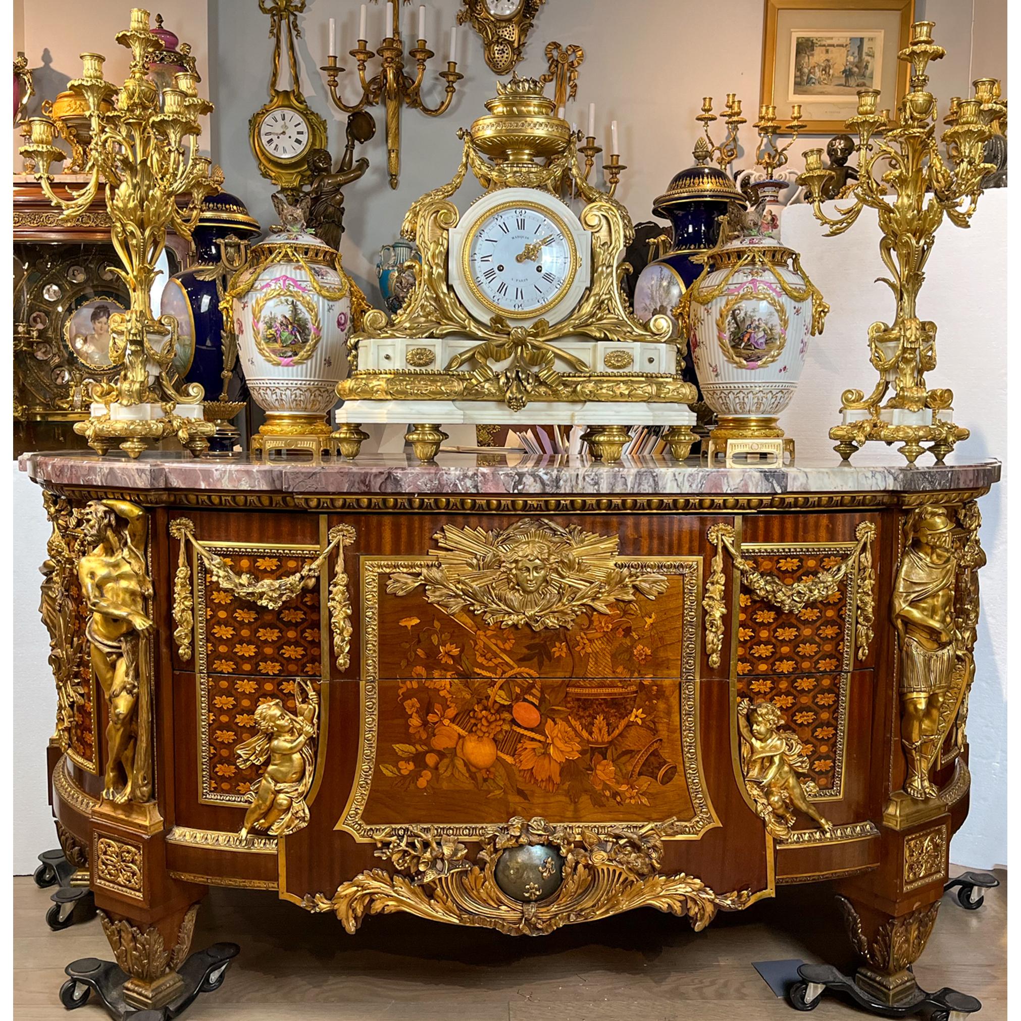 Eccezionale commode francese in stile Jean Louis XVI con intarsio e intarsio in mogano e legno di frutta, con piano in marmo originale, secondo un modello di Jean-Henri Riesener.

 Una coppia di cassetti è guidata da una maschera di Minerva sopra