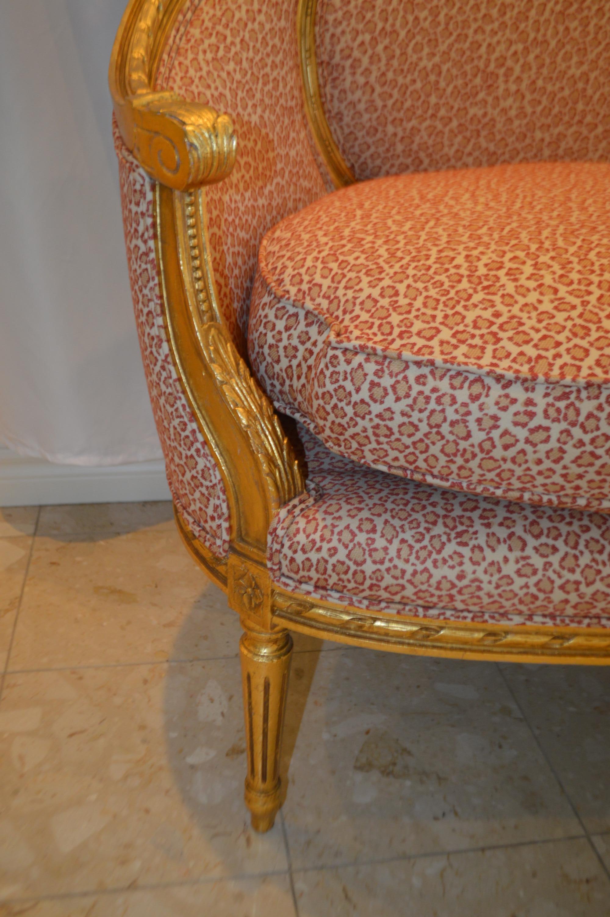 Gilt Louis XVI style gilded settee with pink and cream fabric.
