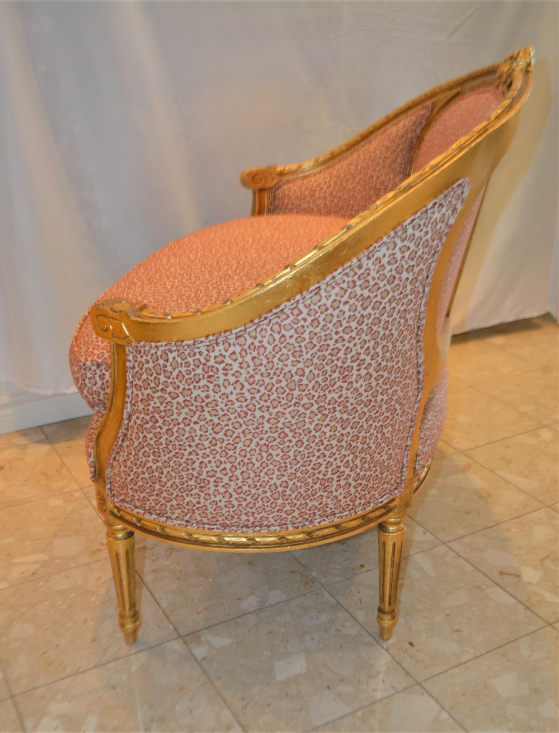 Wood Louis XVI style gilded settee with pink and cream fabric.