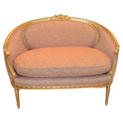 Louis XVI style gilded settee with pink and cream fabric.