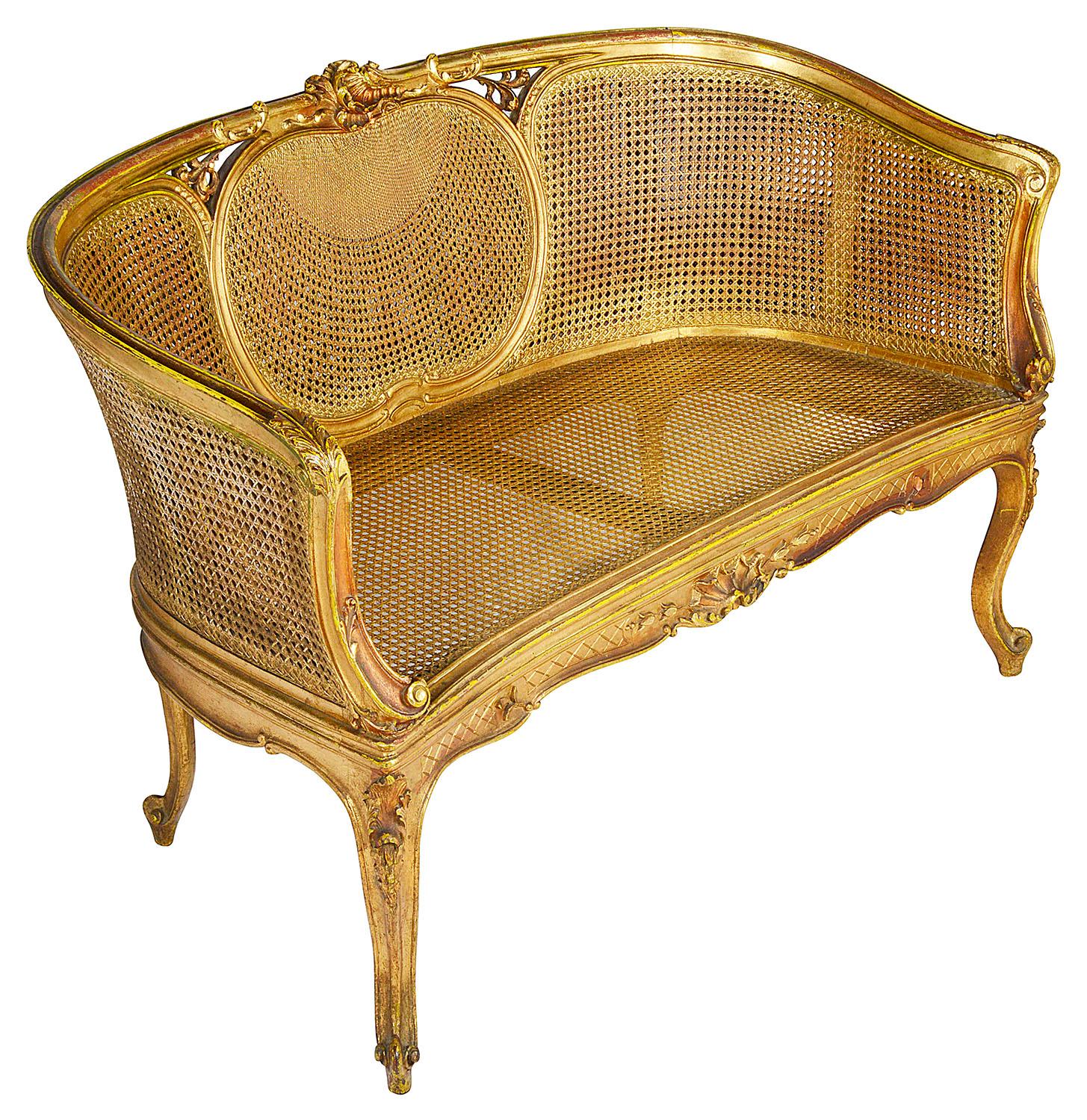 A good quality late 19th century carved giltwood and double cane two-seat salon settee, having scrolling foliate and shell decoration, raised on elegant carved cabriole legs.