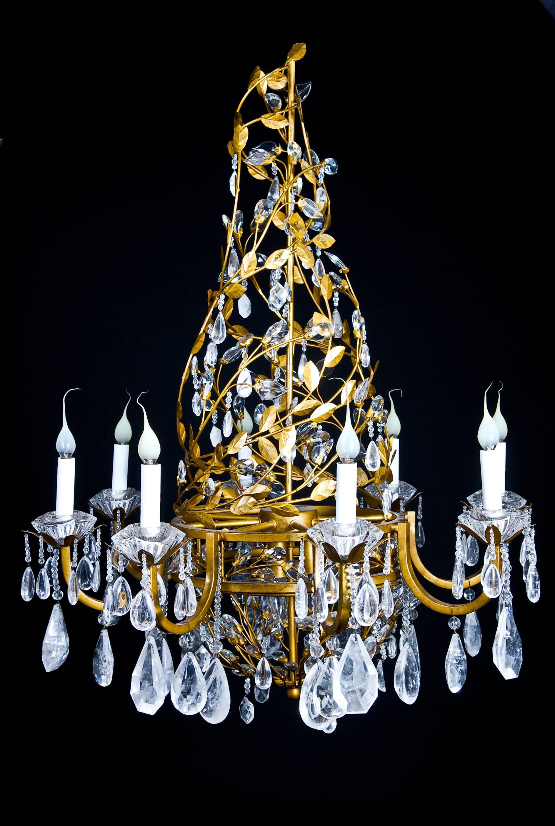 A fine Louis XVI style gilt metal, cut rock crystal and glass multi light chandelier embellished with cut rock crystal prisms and further adorned with glass leaves.