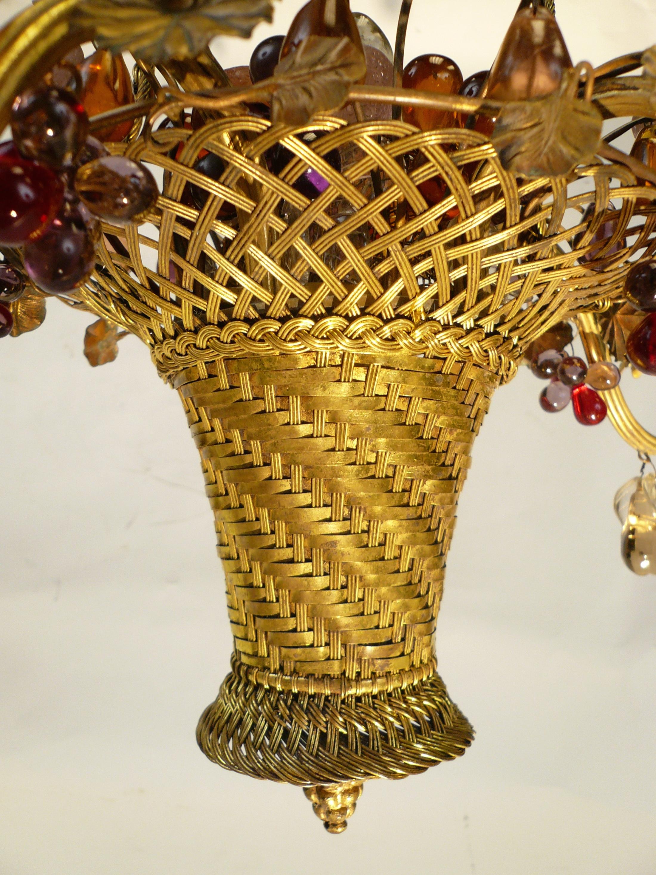 This charming basketweave gilt brass five-arm chandelier features multicolored crystal fruits and drops.
The central fruit basket is illuminated by it's own interior light.