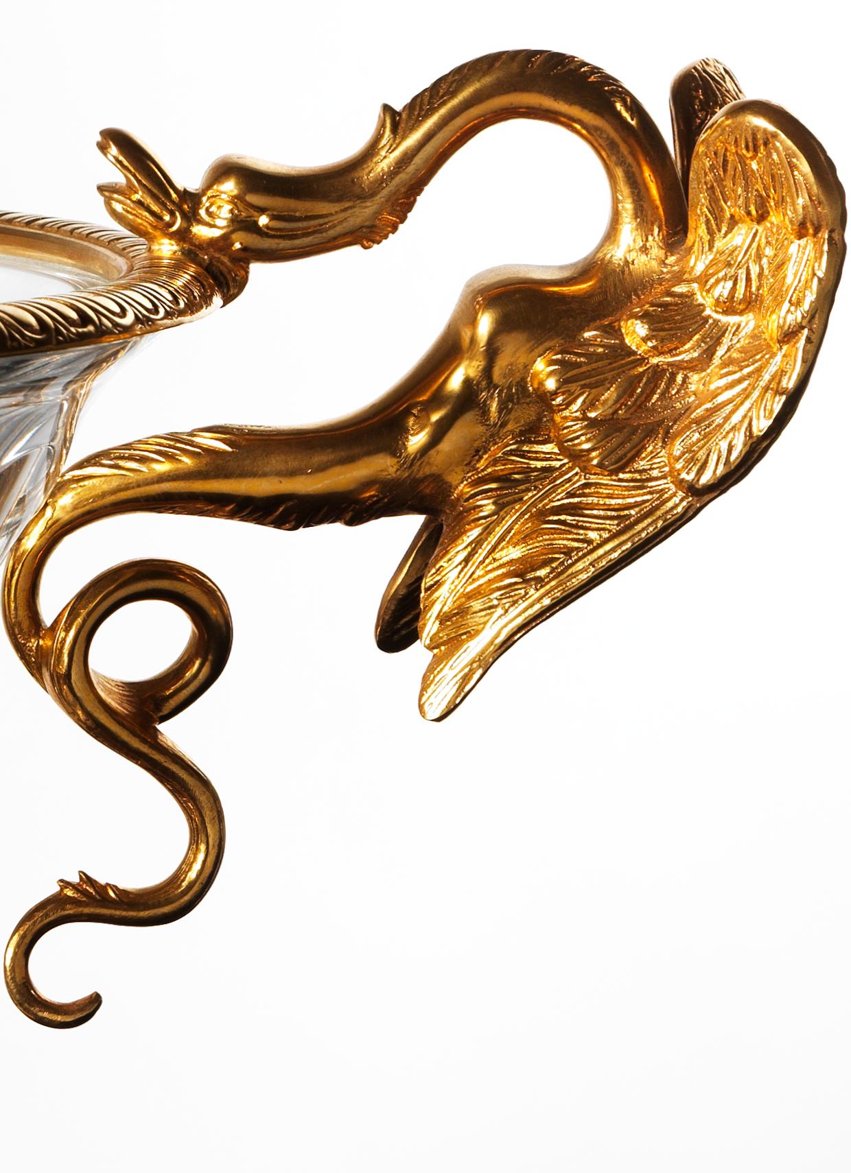 Cette coupe de style Louis XVI en bronze doré et cristal présente un bronze ciselé de haute qualité. Le bord supérieur du gobelet en cristal est orné d'une bordure en bronze avec des gravures géométriques, mais les poignées en forme de dragon