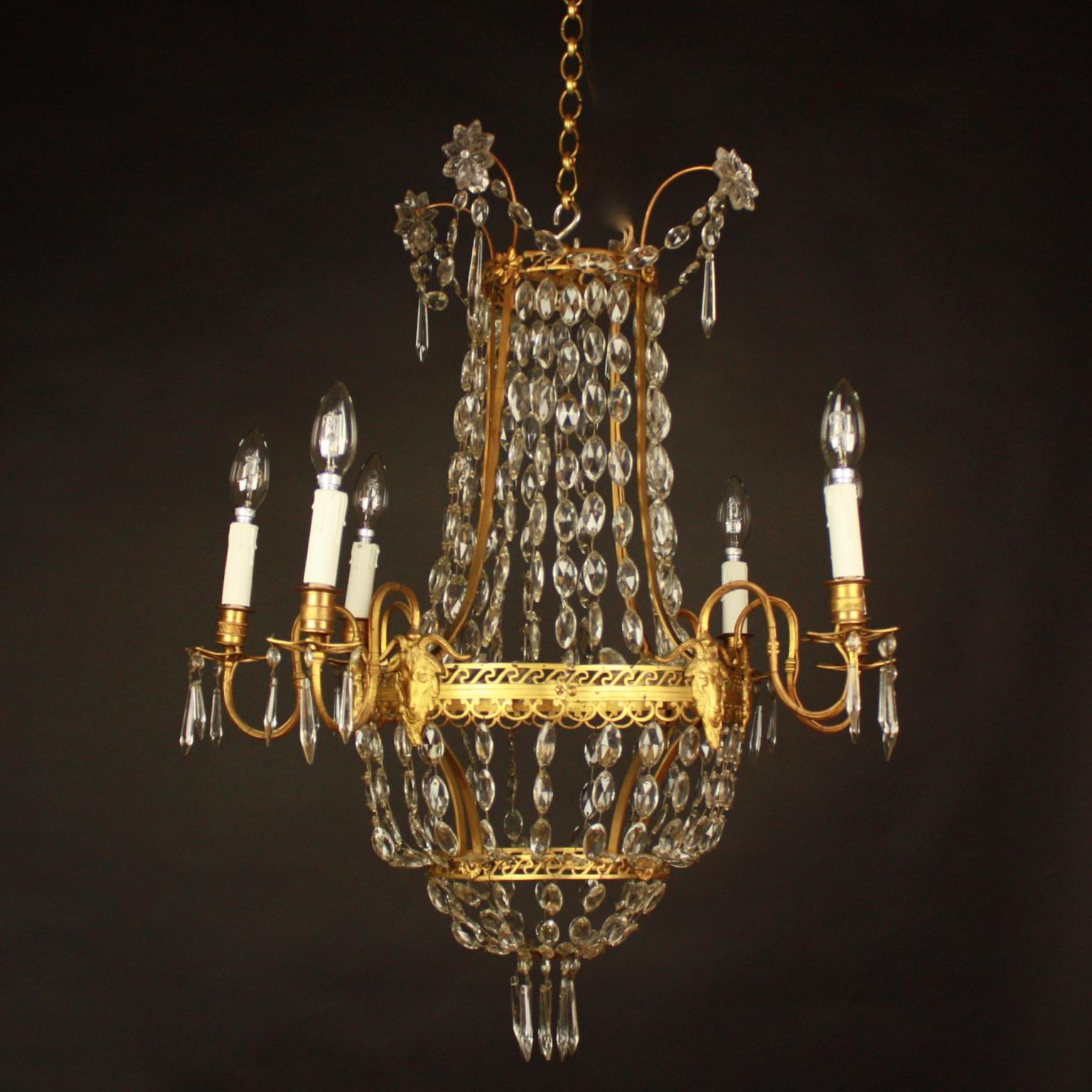 A fine Louis XVI Style gilt-bronze and crystal cut chandelier with six external lights. Surmounted by spray adornment draped with facetted crystals from where chains of lozenge shaped crystal are suspended. Featuring a central pierced bronze tier