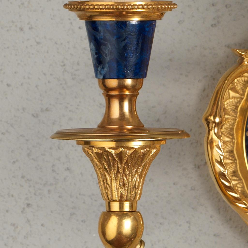 On this Louis XVI style gilt bronze and faux lapis wall sconce by Gherardo Degli Albizzi it's possible to appreciate the handcrafted work of gilt bronze decorations such as branch's vegetal motifs near the centre. The backplate has a geometric