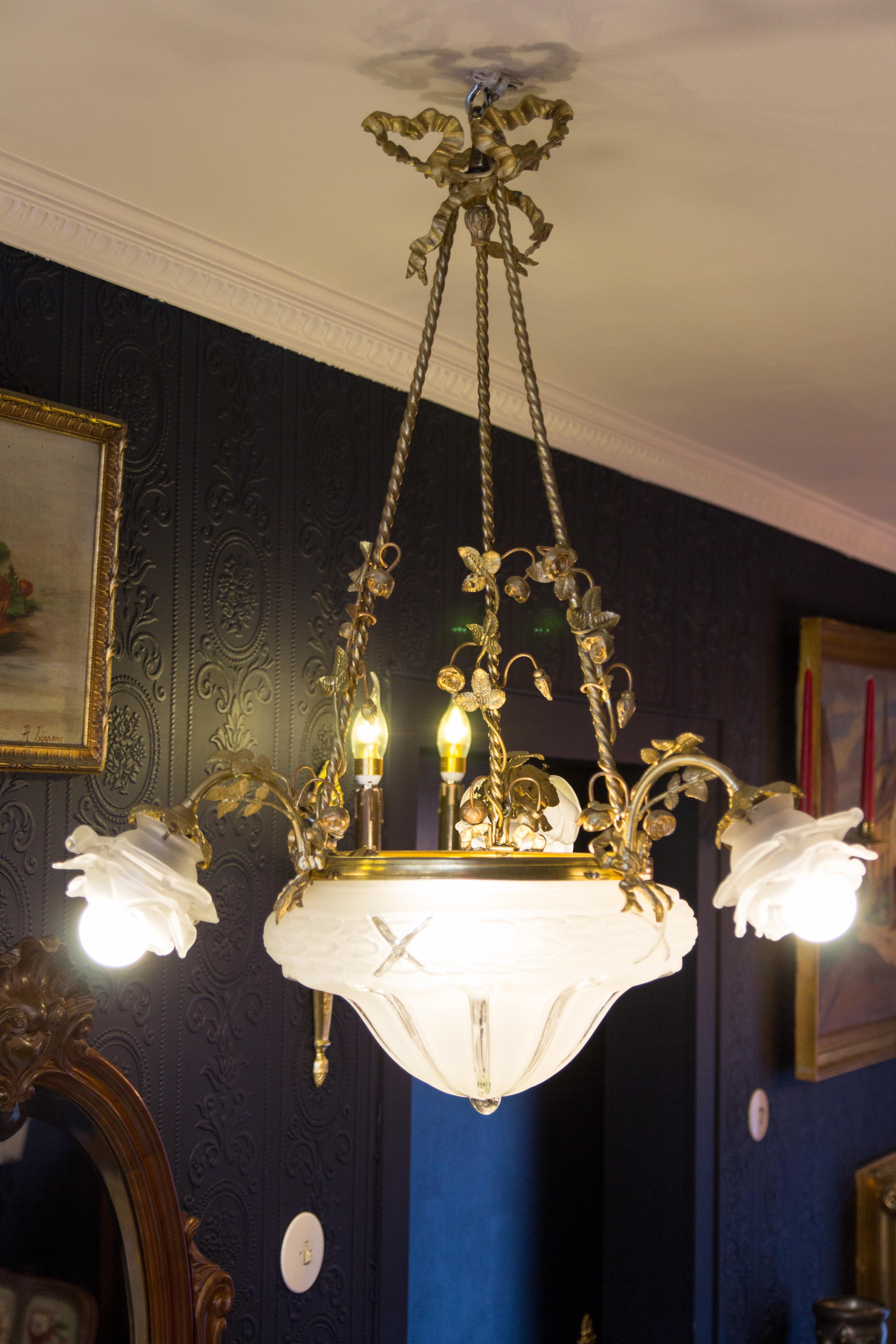 French Louis XVI style gilt bronze and frosted glass four-light chandelier, embellished with bronze flowers, has three arms, each with frosted glass floral shape lampshade and original E27 socket with new wiring.
Measures: Height is 28.3 inches /