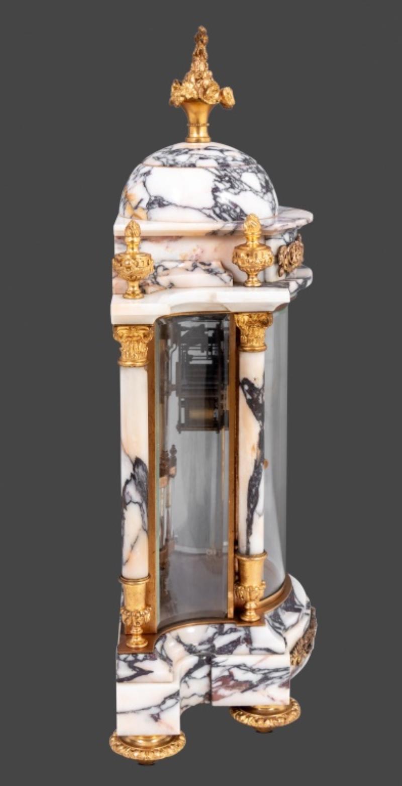 Louis XVI Style Gilt Bronze and Marble Three Piece Clock Set, the clock case with cupola and columnar supports, enameled dial, the movement with mercury compensated pendulum and strike on gong, matching ovoid shaped two handled vases. Clock: 20