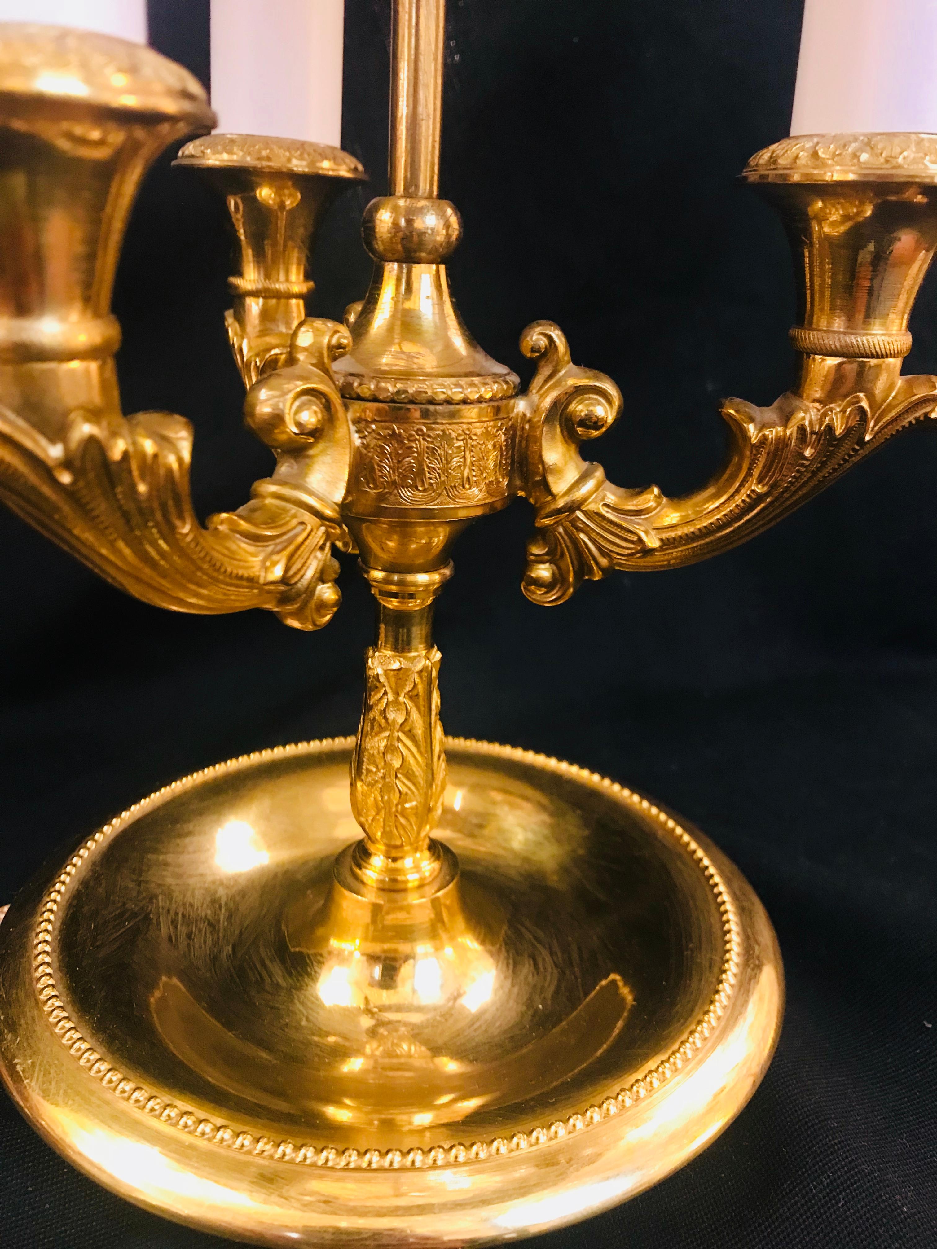 Cette fine et élégante Bouillotte de style Louis XVI en bronze doré et tole peinte par Gherardo Degli Albizzi a trois lumières. L'abat-jour conique Toleware est peint à la main avec de l'émail et présente une décoration de plumes et de végétaux en