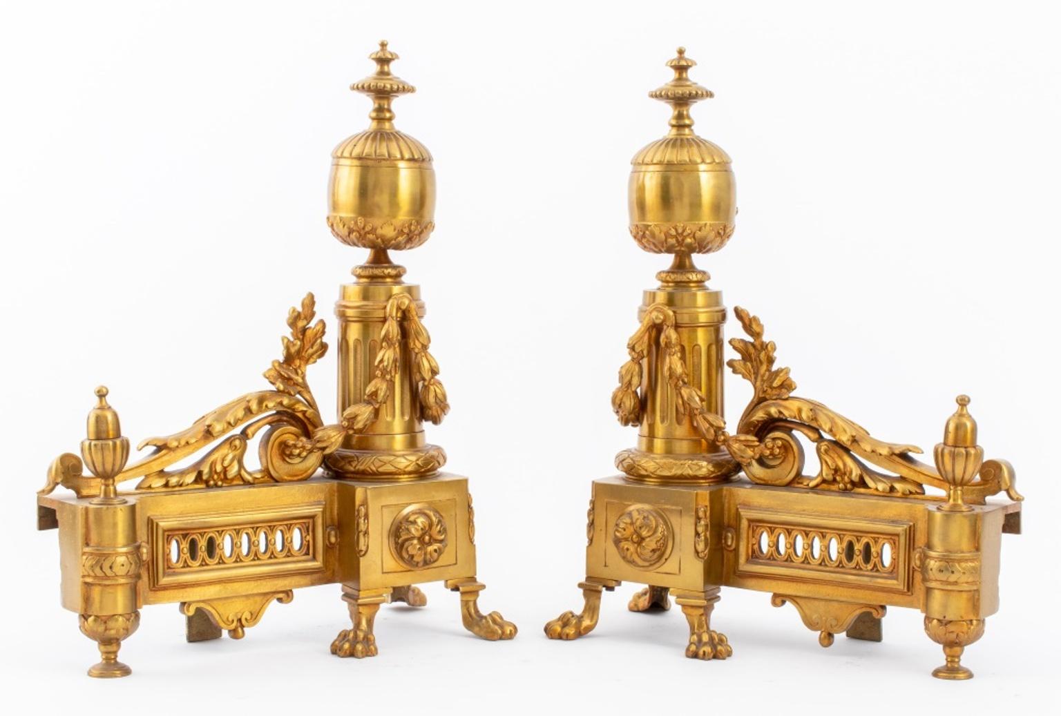 Pair of Louis XVI gilt bronze andirons cast with scrolling foliate design and florettes, each upon four paw feet.

Dimensions: Each: 14.25