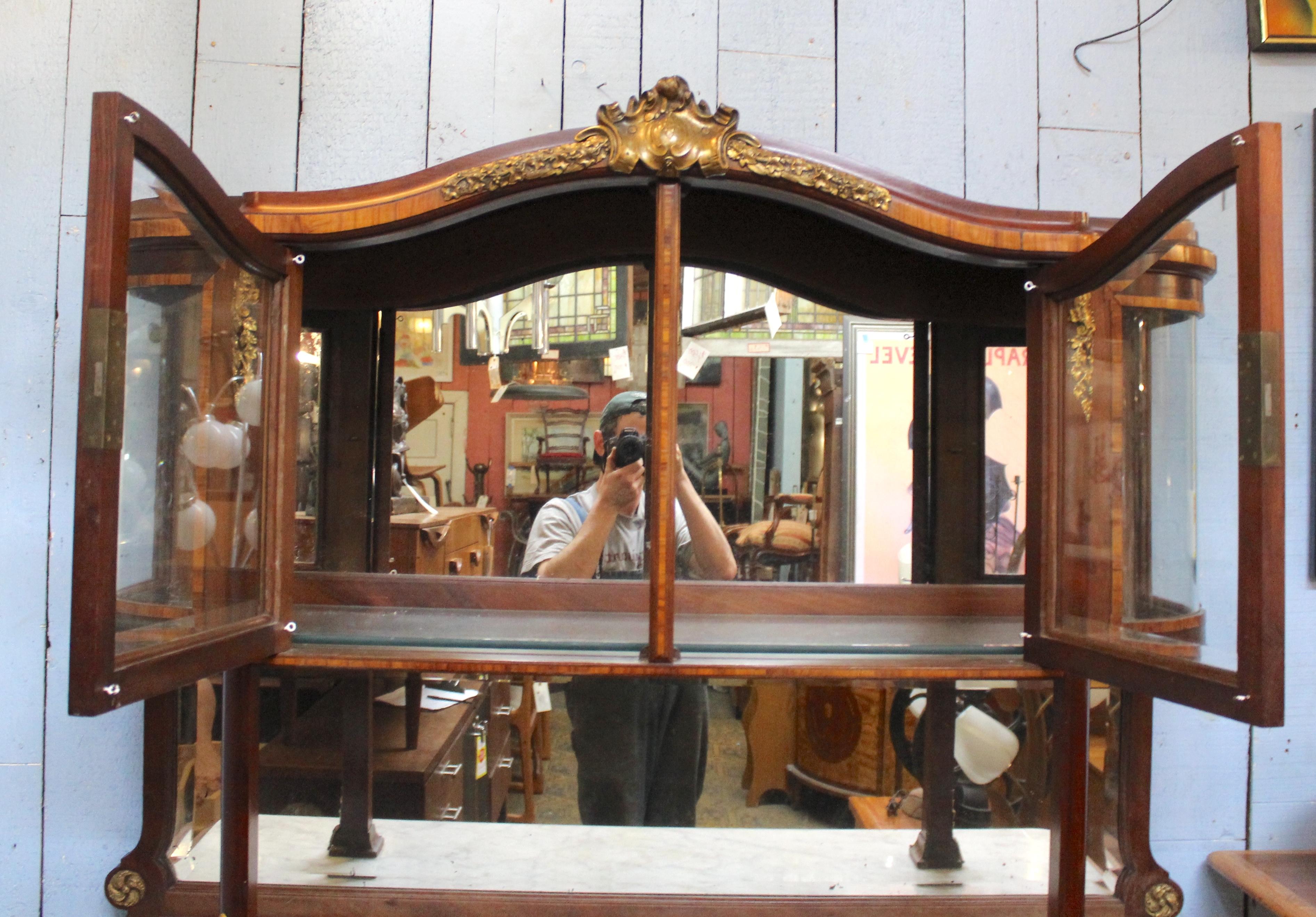Questo magnifico buffet è un pezzo di grande effetto per la tua casa o come stazione di servizio per un ristorante. L'unità è composta da tre pezzi: mobile di base, specchiera posteriore e mobile superiore in vetro. Piano in marmo, ante a raggiera