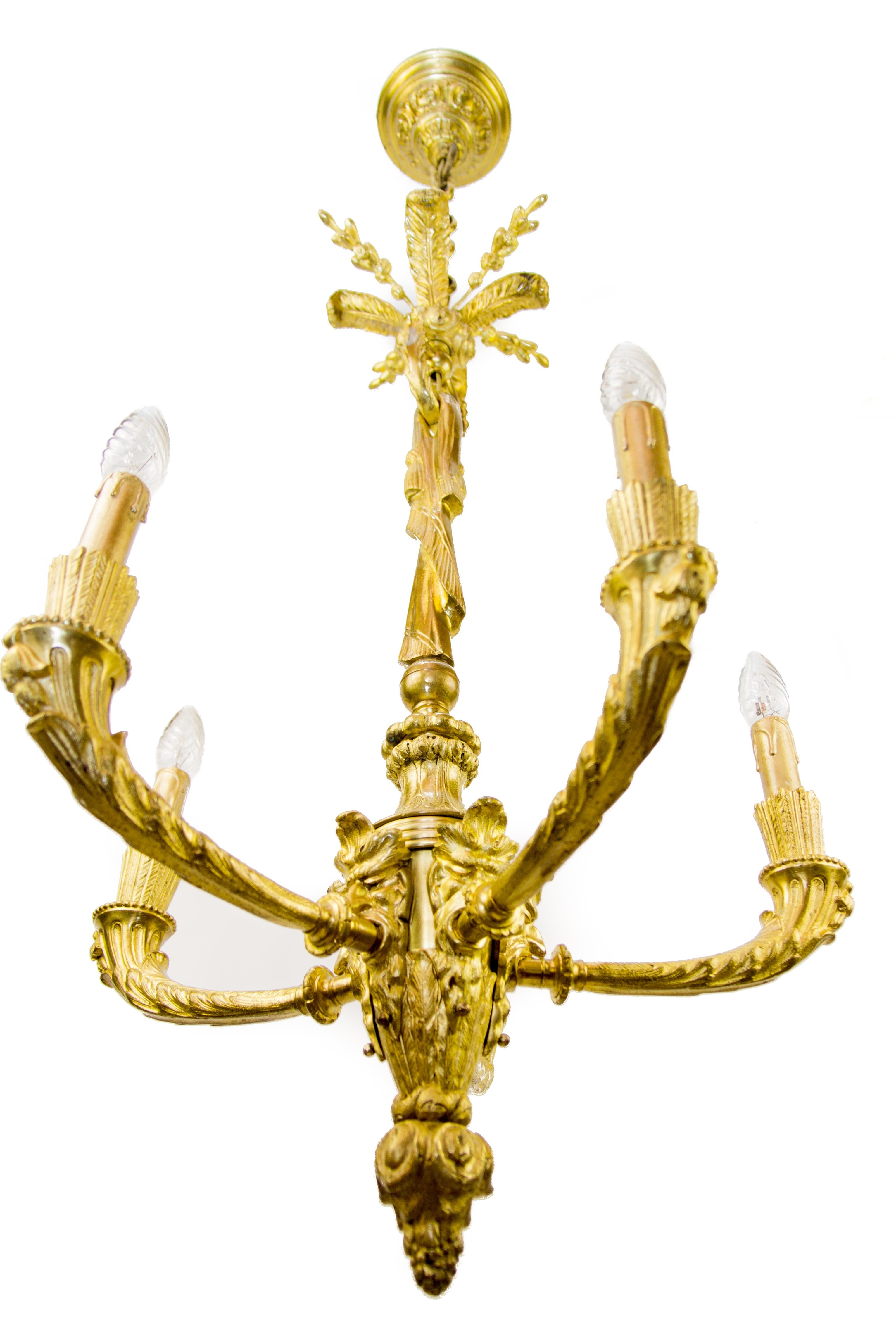 Elegant French Louis XVI style gilt bronze five – light electrified chandelier from the late 19th century, decorated with Bacchus heads and foliate motifs.
Five bronze arms with E14 sockets and new wiring, new red fabric lampshades.
Free delivery in