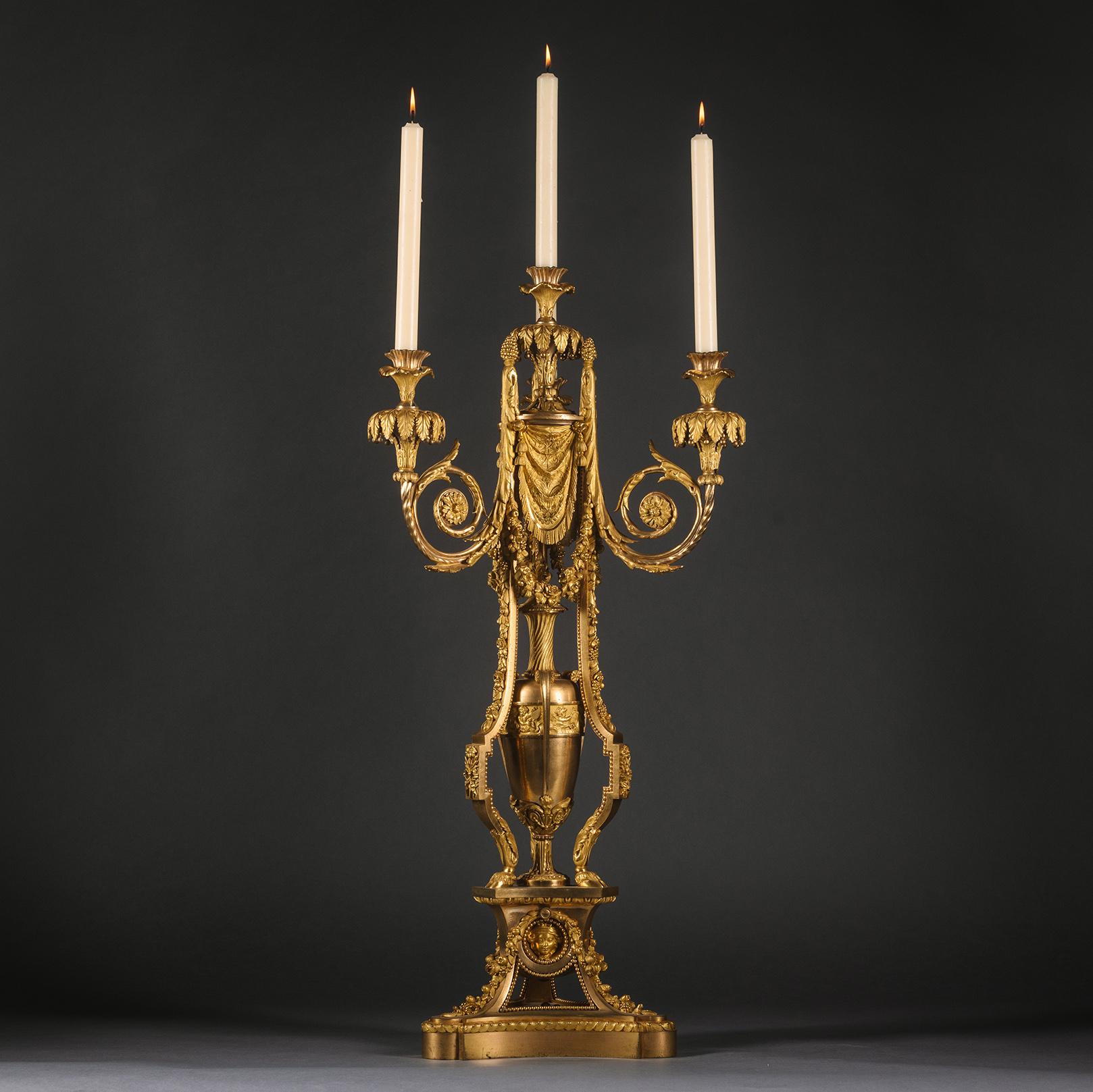 Grand et impressionnant candélabre à quatre lumières en bronze doré de style Louis XVI, d'après le modèle attribué à Pierre Gouthière.

Finement moulée et dorée, avec une tige centrale qui donne naissance à trois branches à enroulement d'acanthe,