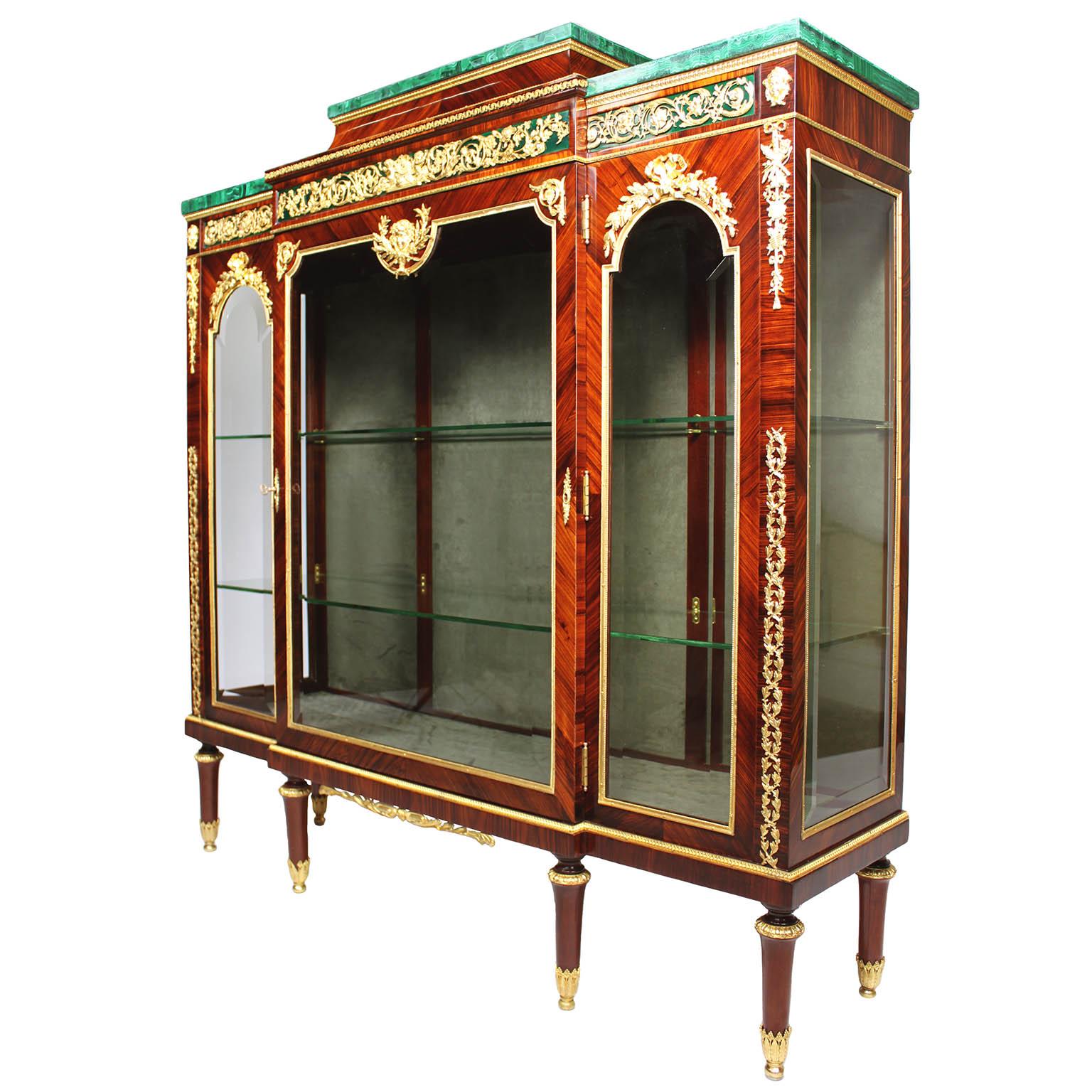 A very fine 19th century Louis XVI style gilt bronze and gilt metal mounted rosewood vitrine cabinet with malachite tops, by Pierre E. Guerin (1843-1911), in the manner of François Linke (1855-1946). The slender single-glazed front door tri-level