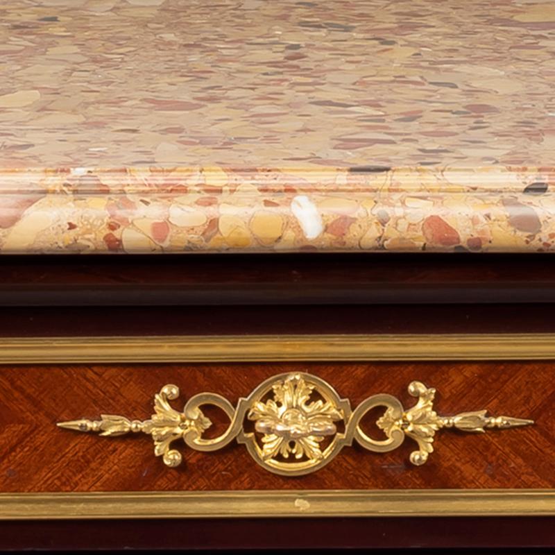 Eine vergoldete Bronzeplatte im Louis XVI-Stil mit einer Marmorplatte aus Breche d'Alep.

Die Kommode hat eine rechteckige Marmorplatte aus Breche d'Alep über einem Fries mit drei Schubladen und steht auf spitz zulaufenden Beinen mit blattförmigen