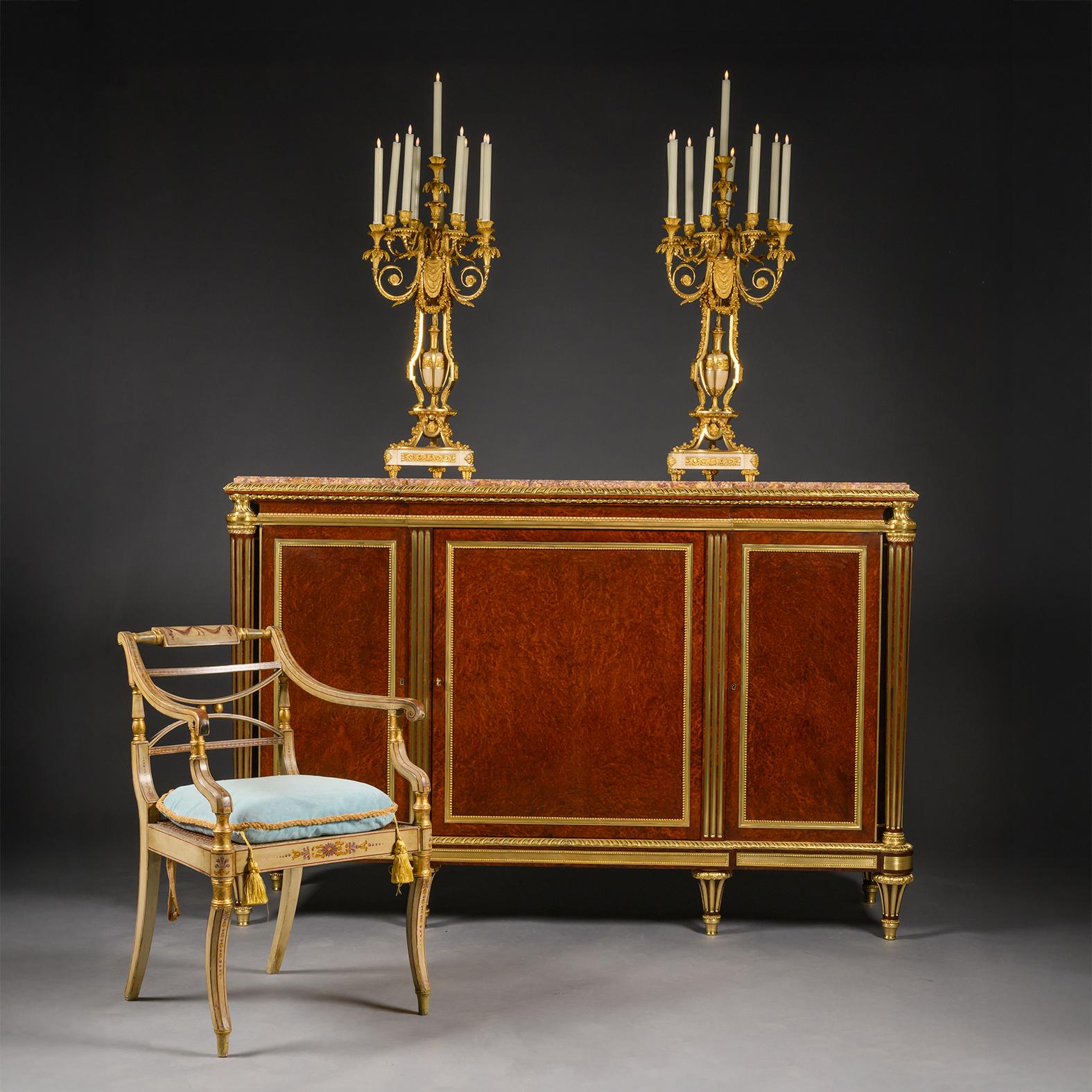 Fino mueble auxiliar de bronce dorado montado en rebabas estilo Luis XVI, de Escalier de Cristal, París. Después del Modelo Por Adam Weisweiler. 

El contorno del frente tiene un ribete de cinta de bronce dorado alrededor de una encimera de mármol