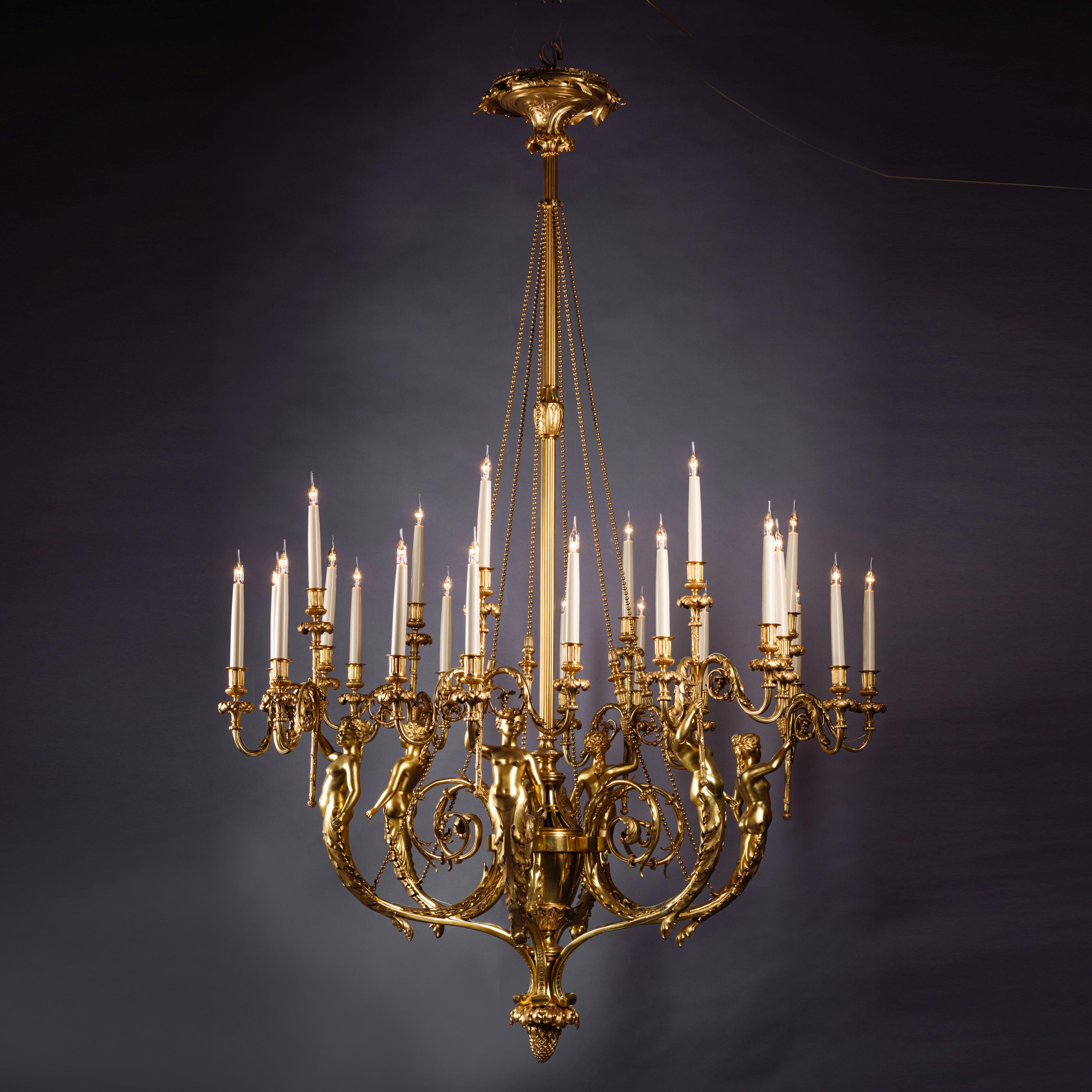 A magnificent Louis XVI Style gilt bronze twenty-four-light figural chandelier.

This fine chandelier is of large size at over 185 cm (73 inches) high. Finely cast in gilt bronze it features a fluted central stem with suspended beaded chains above