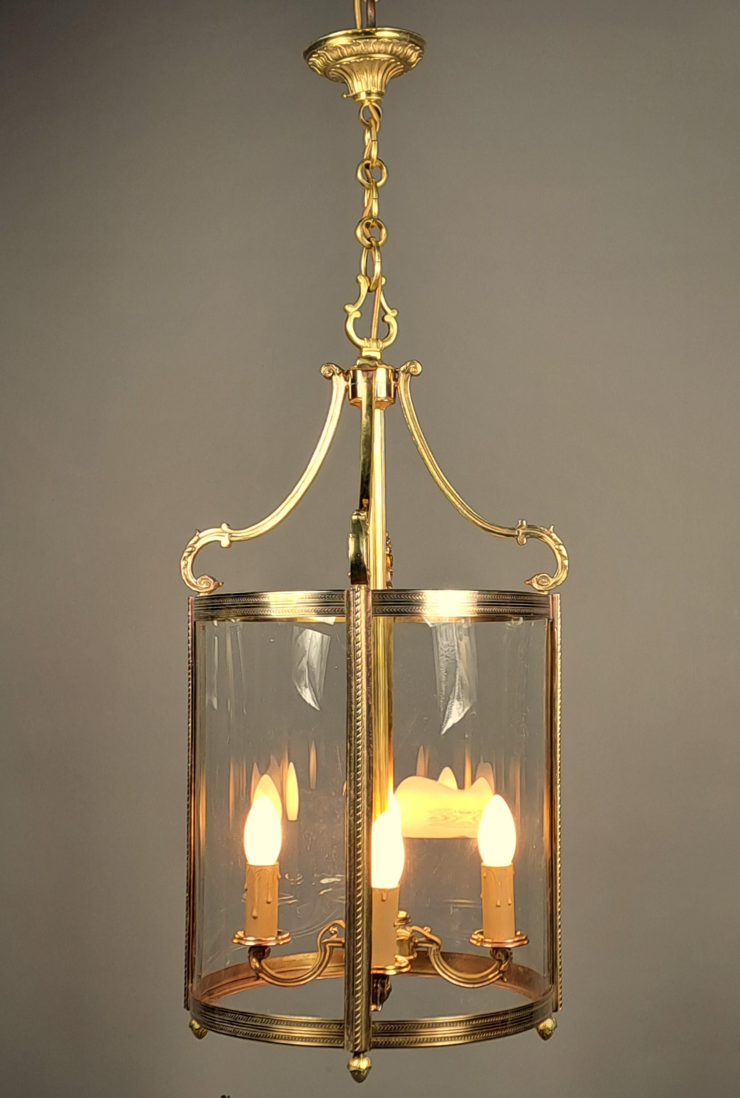 Große Laterne im Louis-XVI-Stil aus vergoldeter Bronze und gewölbtem Glas, mit vier Lichtern.  Verkauft mit der Kette und dem vergoldeten Deckenbaldachin aus Bronze.   Französisches Werk von guter Qualität aus den 1950er Jahren,  Sehr guter Zustand,