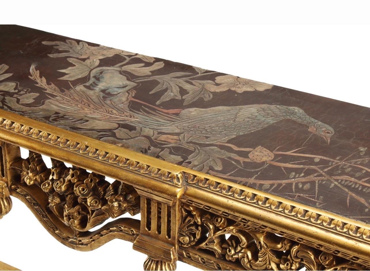 A Louisiana XVI style console table, age unknown, but vintage, with an antique Chinese Coromandel panel and set in the top.

The table is gilded, with fluted and tapered legs and intricately carved apron featuring vines and flowers.

The Coromandel