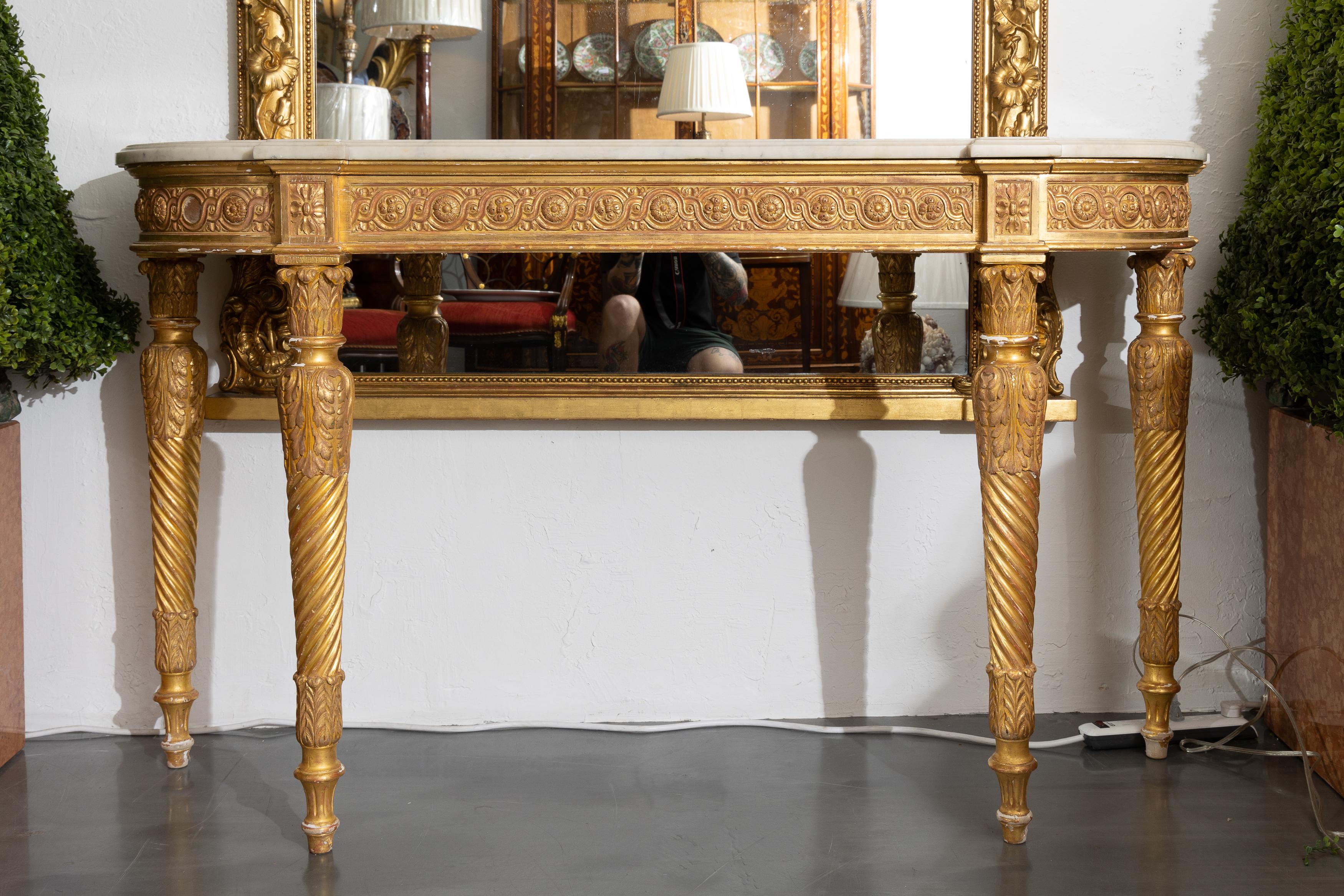 This is French Louis XVI style gilt console, the white marble top over ornamental frieze, supported by round tapered legs.