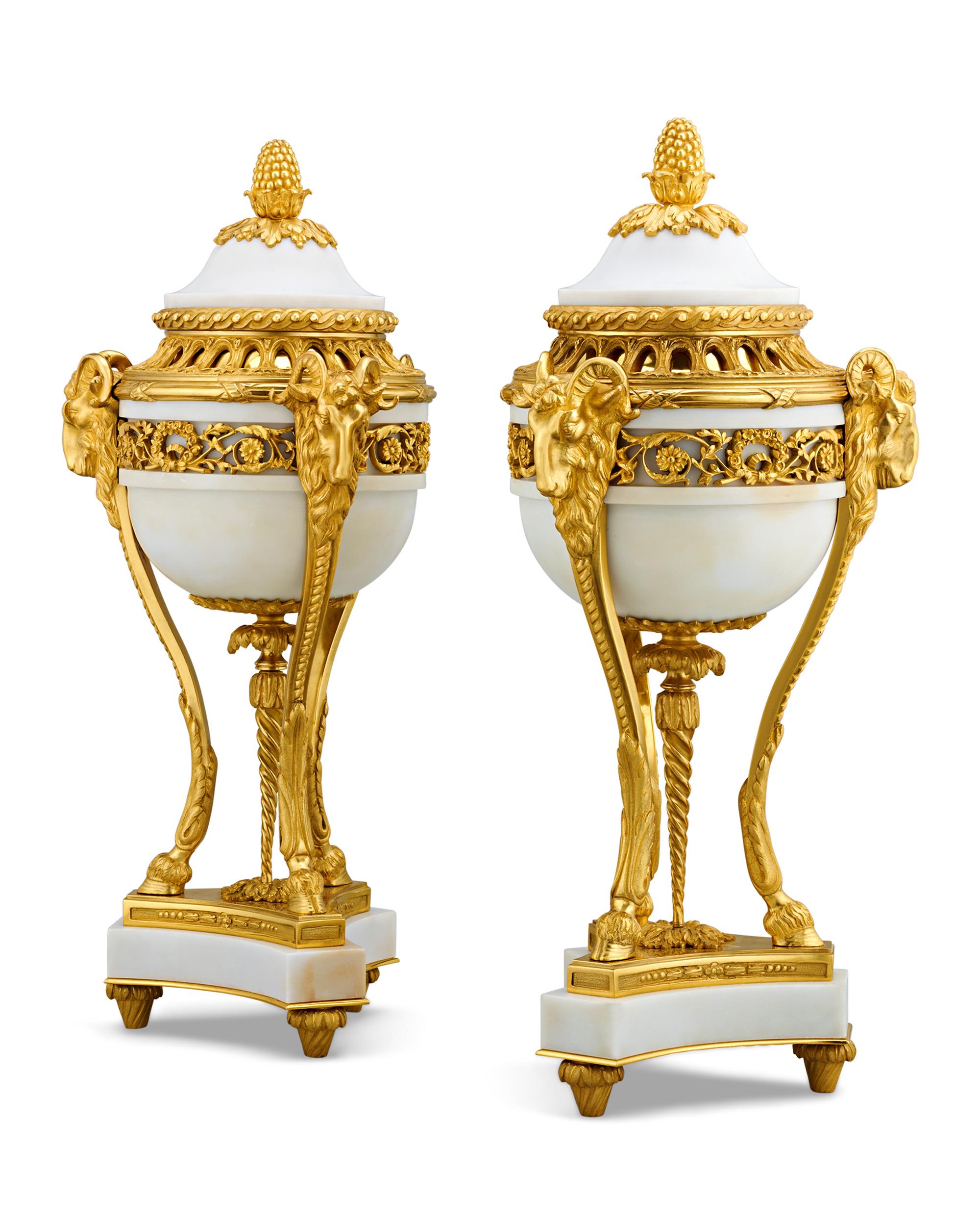 The bodies of this pair of Louis XVI-style vases, measuring nearly two feet in height, are formed from stunning specimens of white marble. Doré bronze mounts in the Louis XVI style perfectly contrast with the bright hues of the hardstone. Classical