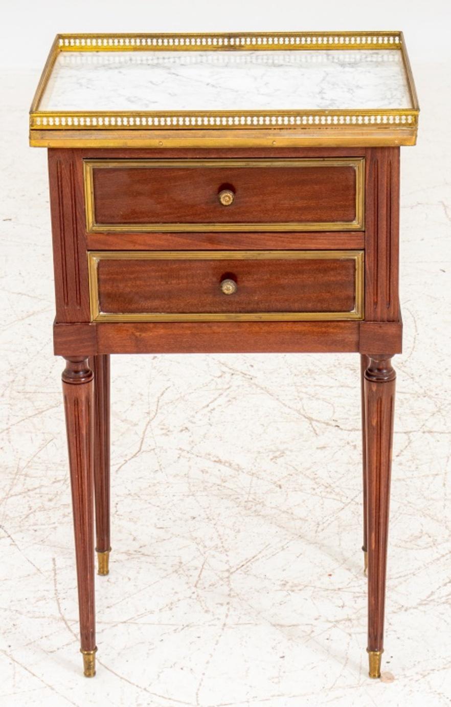 Louis XVI style gilt metal mounted Carrara marble topped side table, with galleried rectangular top above two short drawers on cylindrical tapering fluted legs on toupie feet. 

Dealer: S138XX.