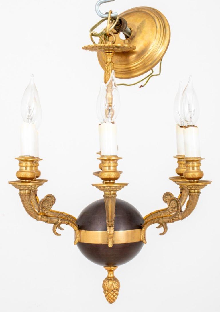 Louis XVI style parcel gilded and patinated bronze six-light chandelier with acanthus cast pendant rod atop a bronze sphere with gilt girdle issuing six volute form candle arms above an acorn pendant finial. 

Dealer: S138XX