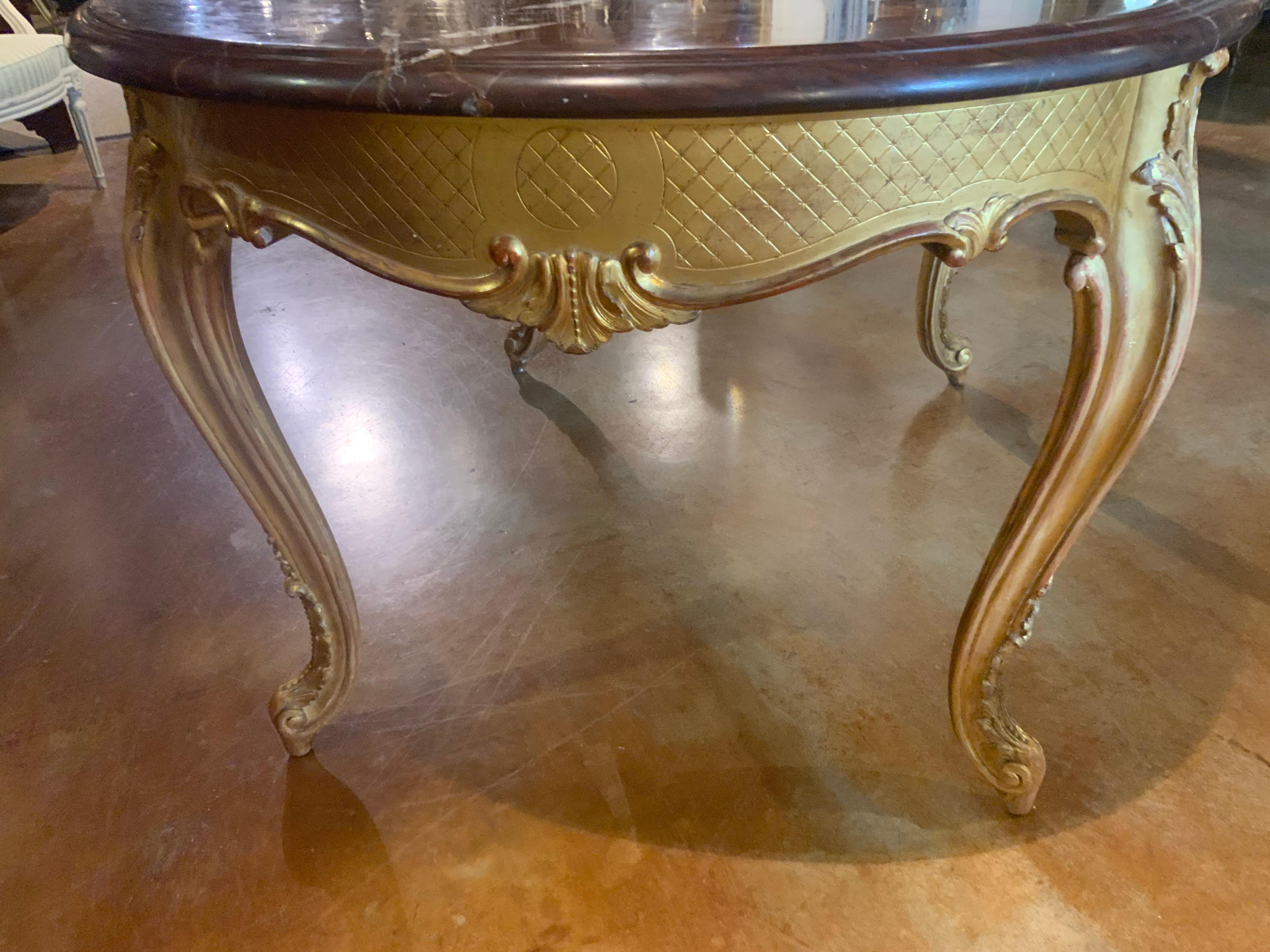 This Louis XVI-Style giltwood center table is excellent on all sides
Exhibiting fine carving and light gold patina to the gilding. It is
Early 20th century and it has thick , oval rouge griotte marble
Top with beveled edges over aprons with incised