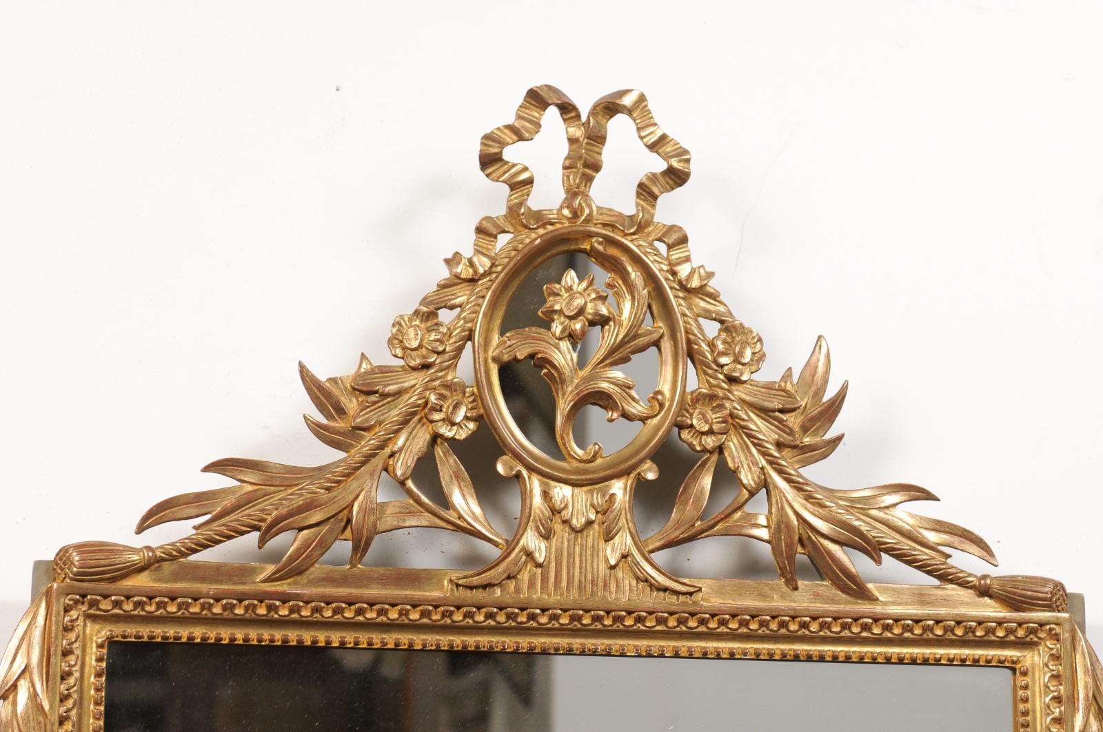 French Louis XVI Style Gilt Wood Mirror with Floral Carved Medallion Crest and Tassels For Sale