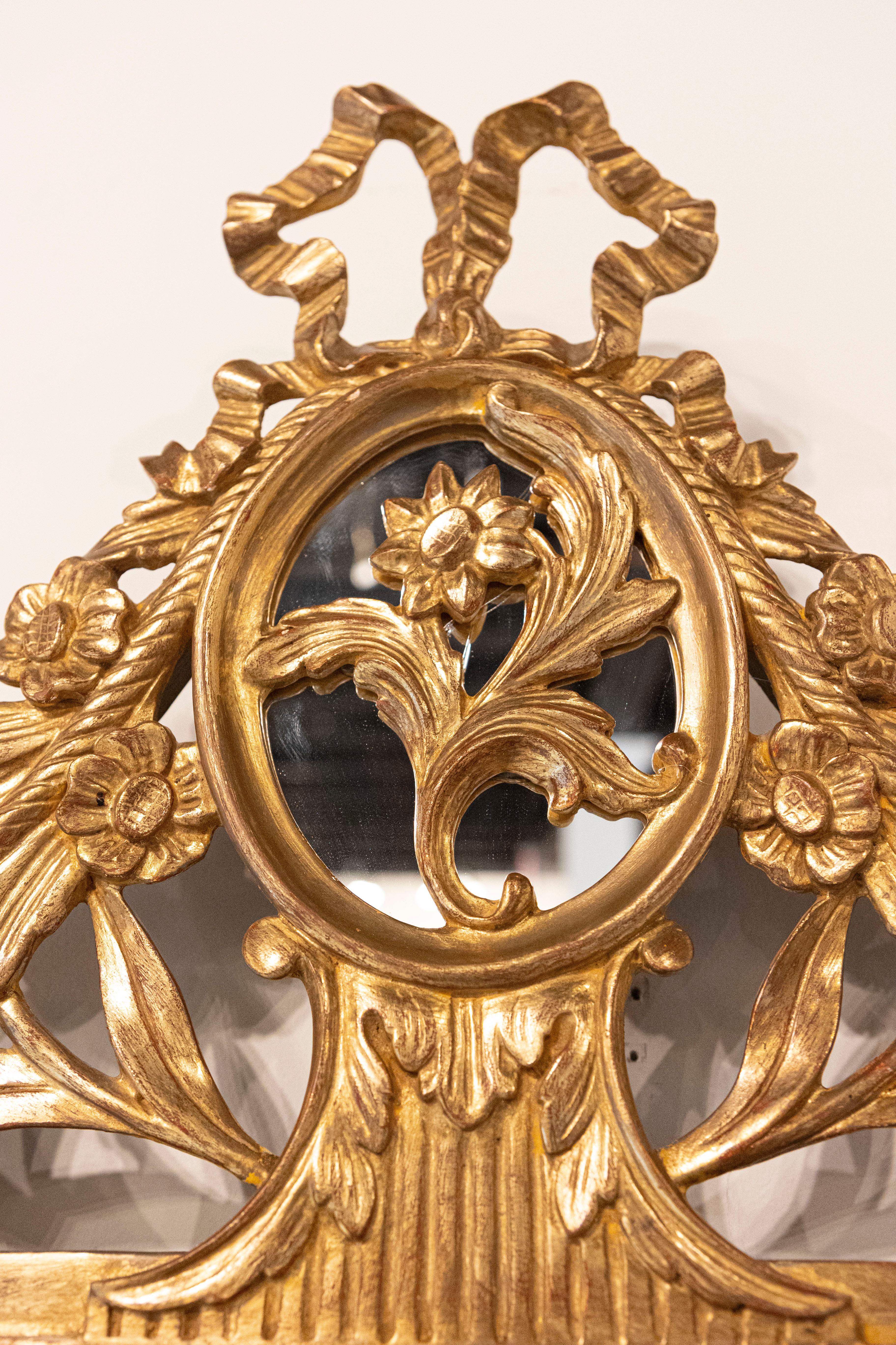 Sculpté Miroir en bois doré de style Louis XVI avec crête et pompons sculptés à motifs floraux en vente