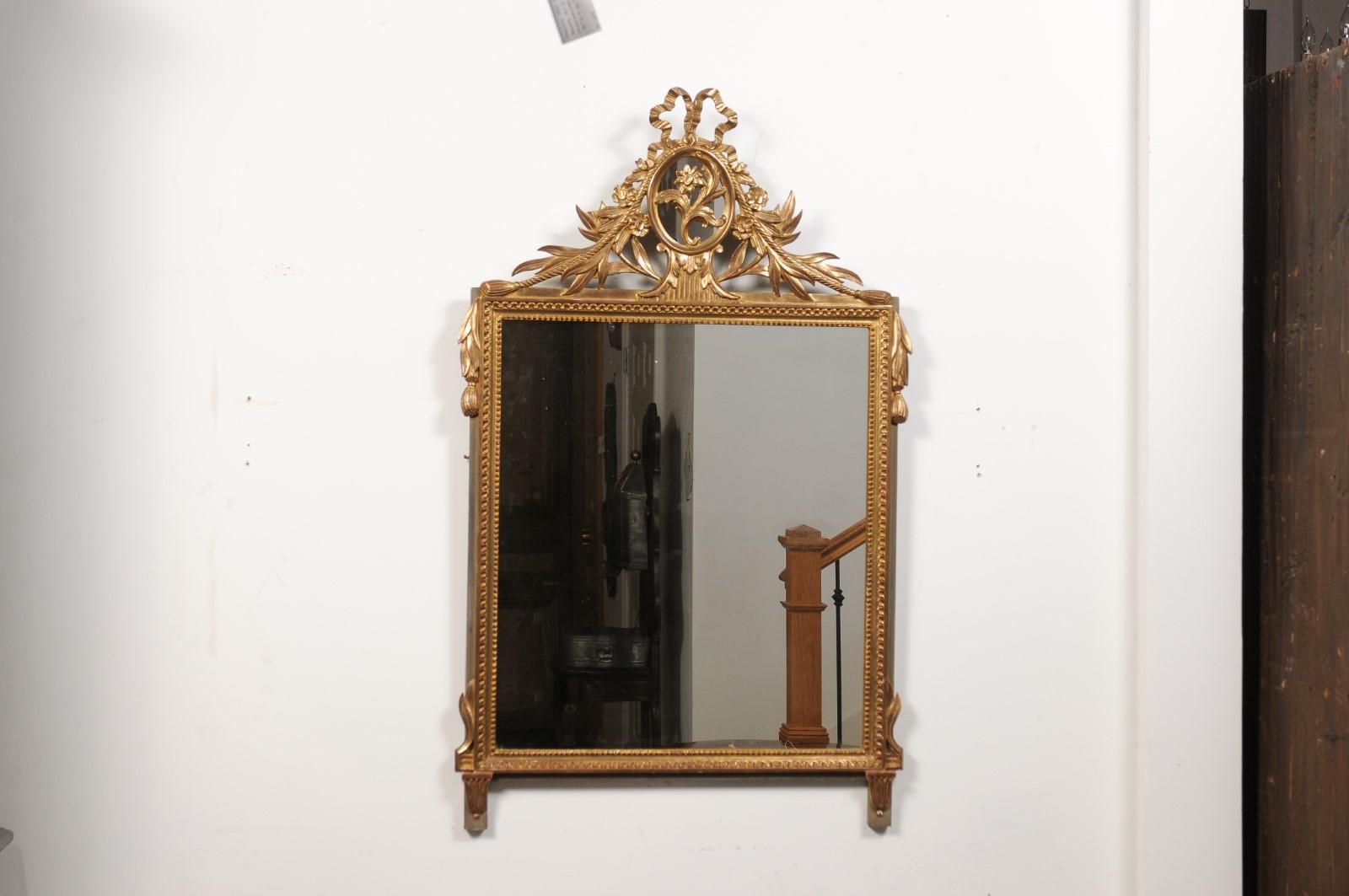 Vergoldeter Holzspiegel im Louis-XVI.-Stil mit geblümt geschnitztem Medaillonkreuz und Quasten (Geschnitzt) im Angebot
