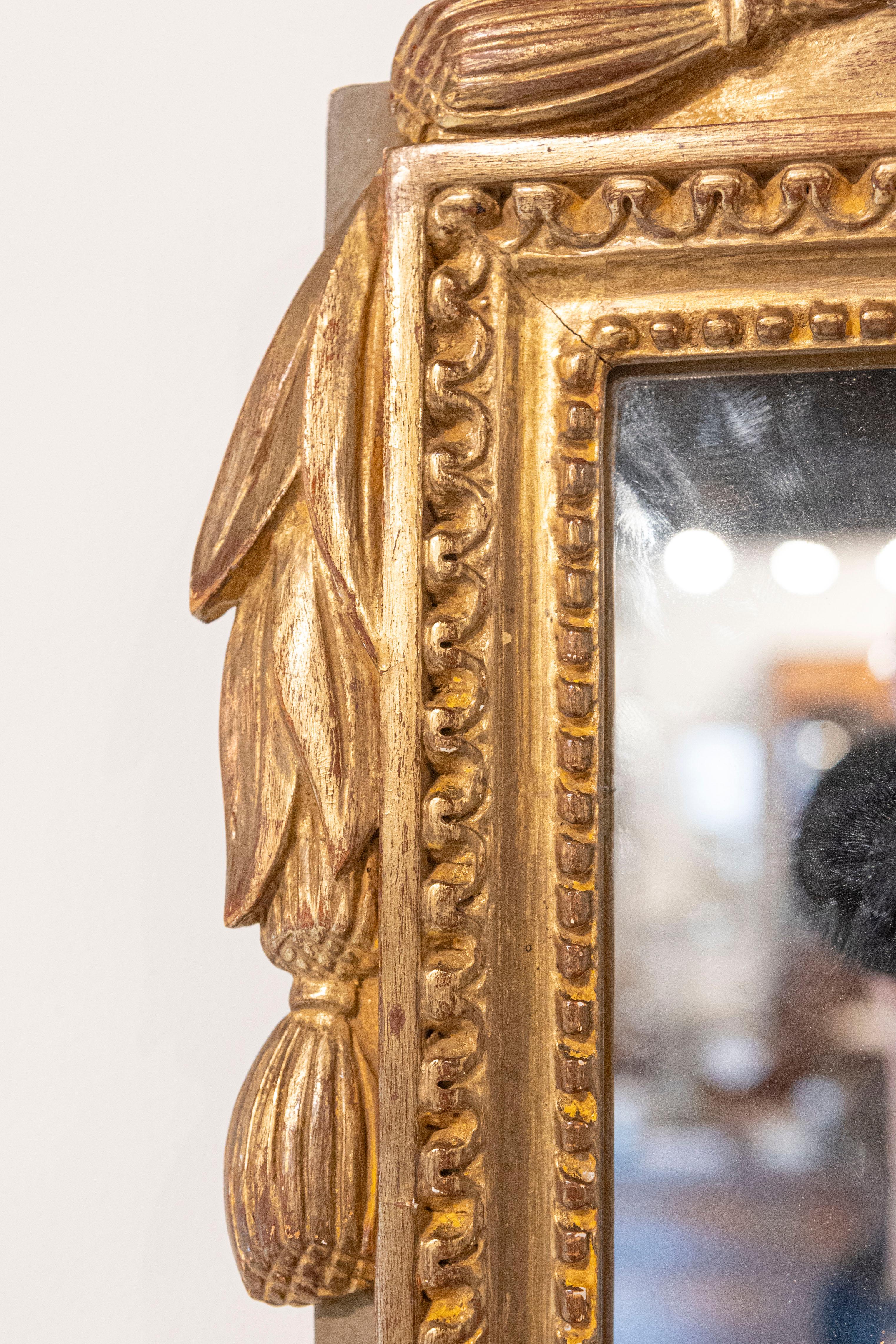 20ième siècle Miroir en bois doré de style Louis XVI avec crête et pompons sculptés à motifs floraux en vente