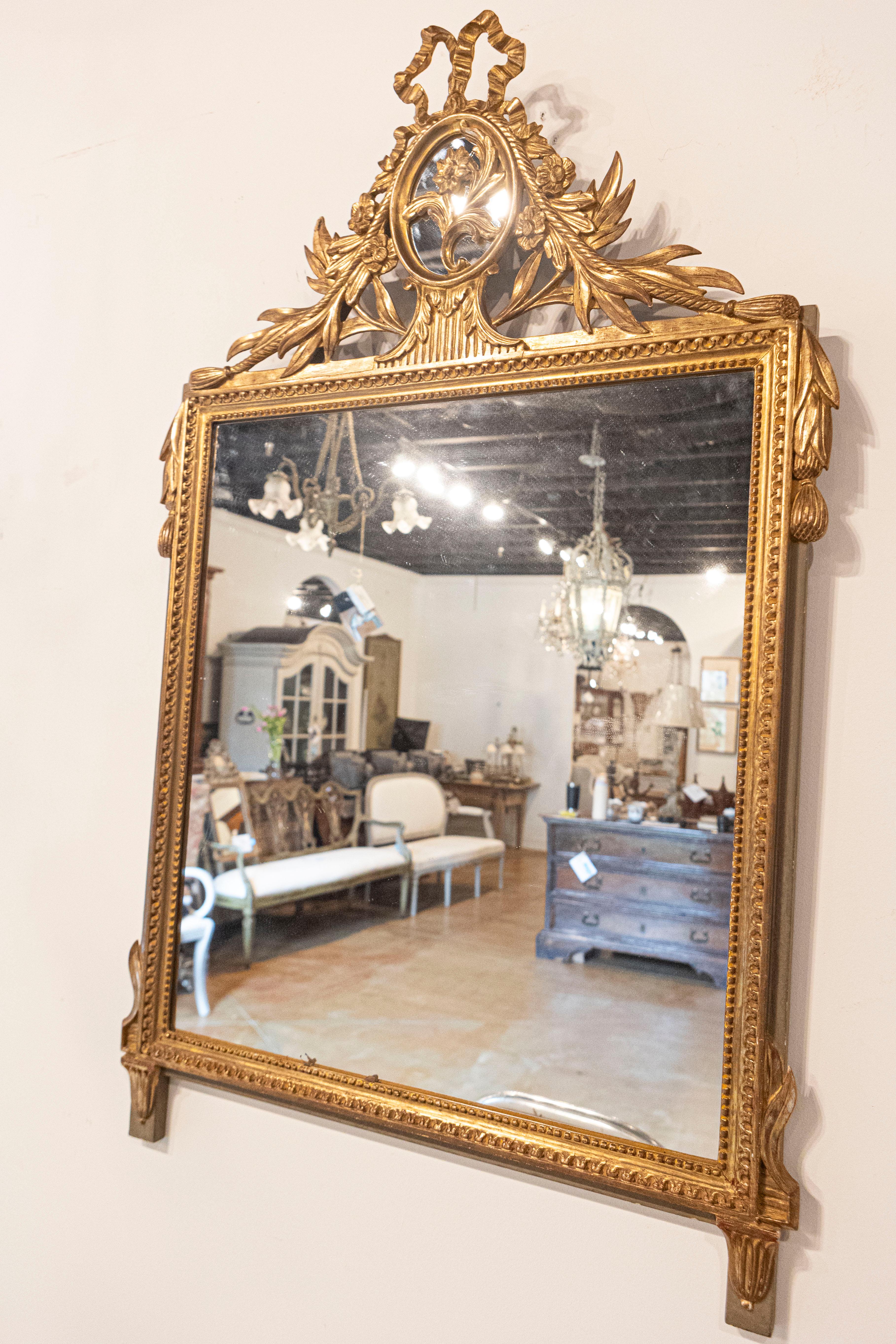 Miroir en bois doré de style Louis XVI avec crête et pompons sculptés à motifs floraux en vente 1