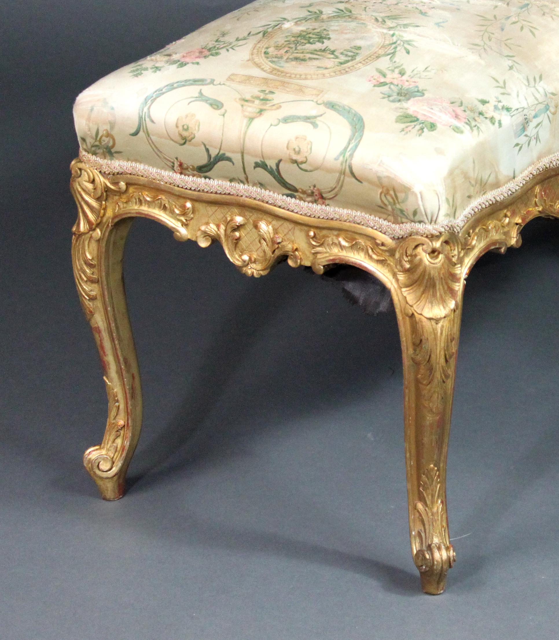 A fine Louis XVI style giltwood cabriole leg stool with with carved detail: shells, acanthus leaves and foliage. Most of the original gilding intact with the attractive red bole showing through in places. The gilding on the feet is slightly worn and