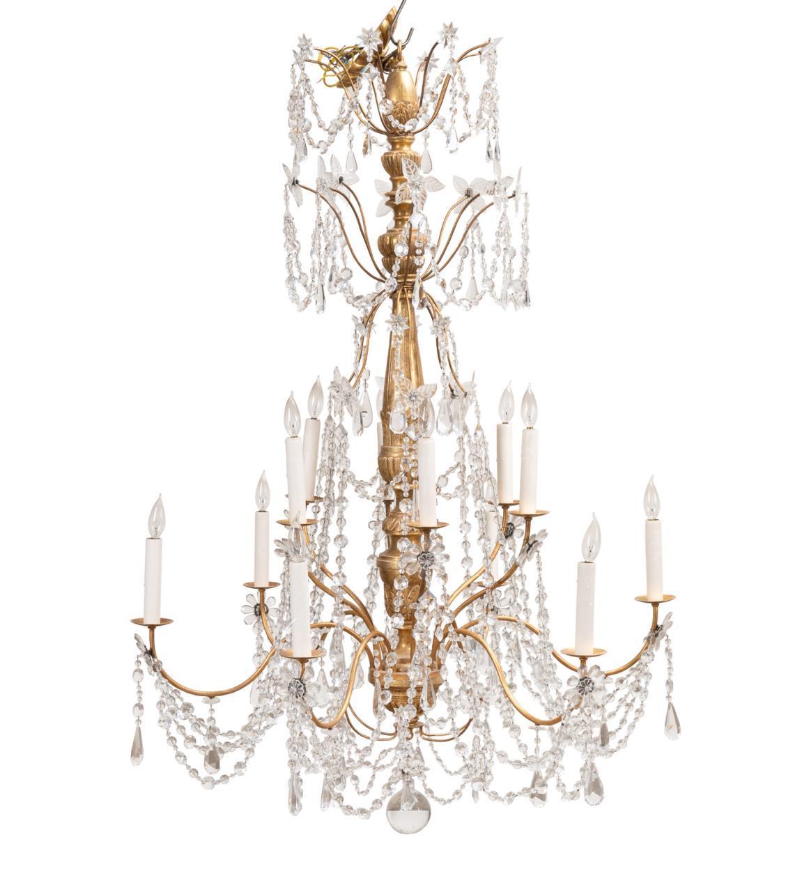 Magnifique lustre de style Louis XIV, avec une tige centrale finie à la feuille d'or 22K et suspendue à des chaînes et des prismes en cristal incolore. 12 lumières. 
Dimensions Hauteur 60  Diamètre  42