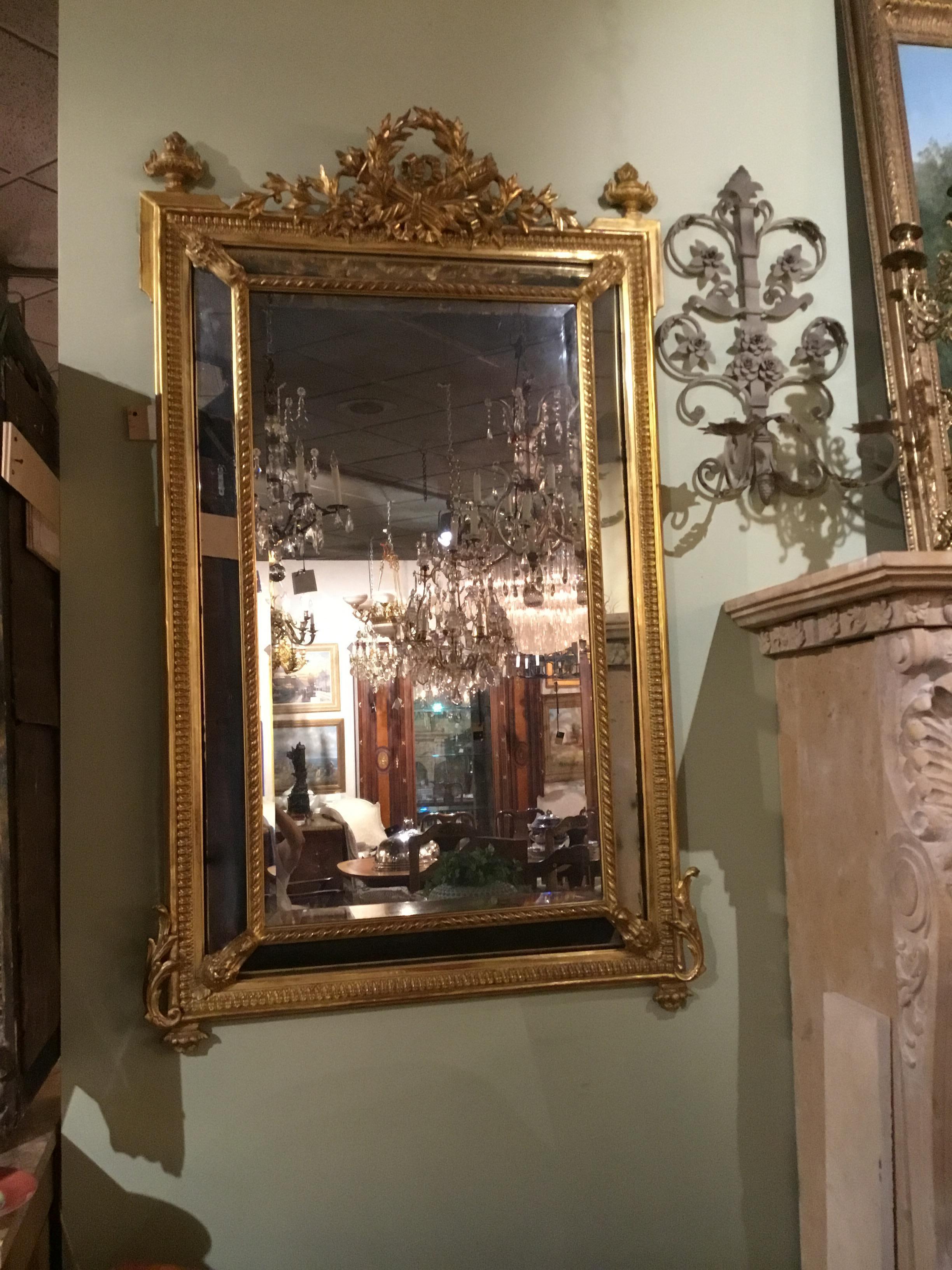 Exceptional giltwood Louis XVI-style cushion mirror, double framed with beveled plate.
Torch and quiver center at the top.