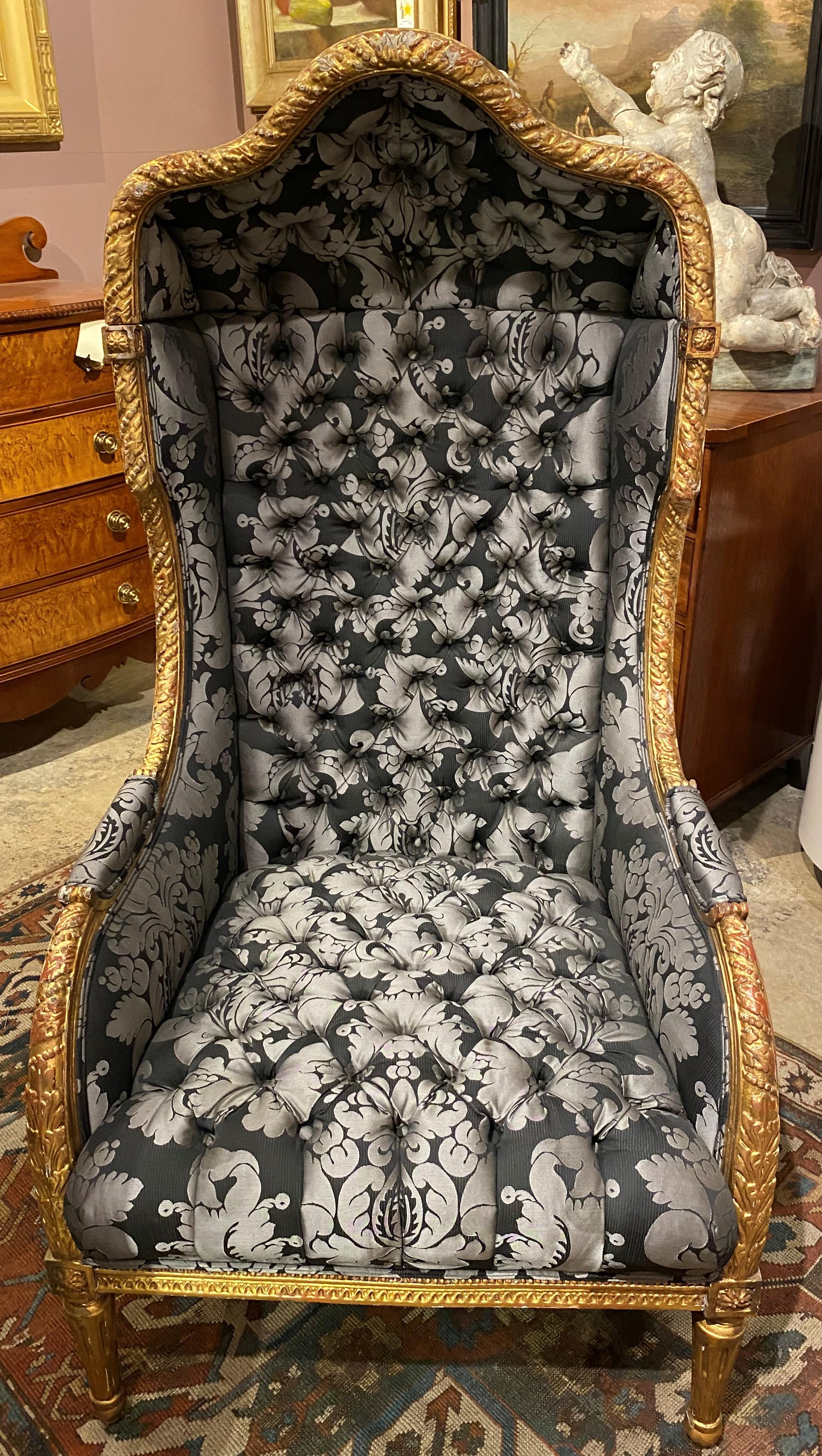 A fine example of a Louis XVI style porter’s or hood chair with carved giltwood frame, tufted gray foliate upholstery, supported by four tapered carved gilt legs. Very good overall condition, with some gilt losses, and minor imperfections and wear