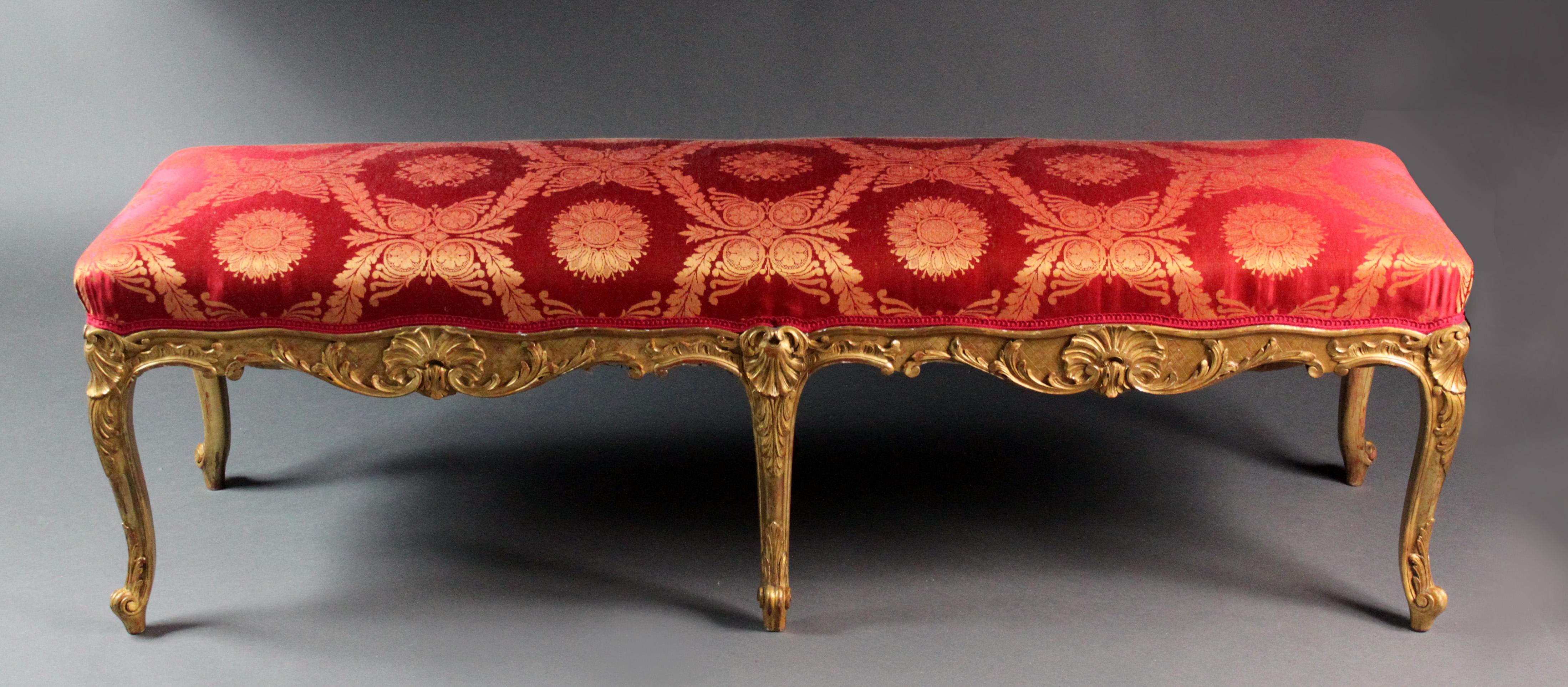 A fine Louis XVI style giltwood cabriole leg stool with carved detail: shells, acanthus leaves and foliage. Most of the original gilding intact with the attractive red bole showing through in places.
Recently re-covered in red and gilt silk.
