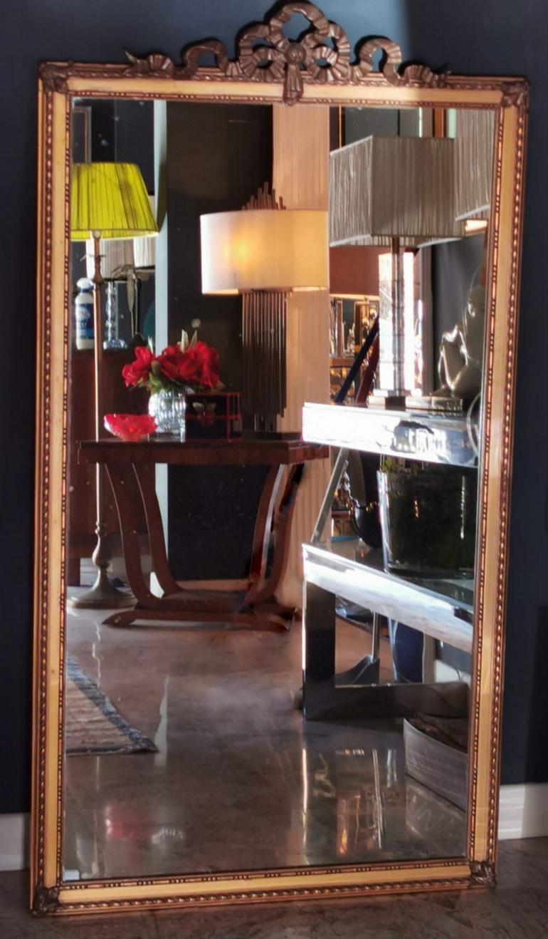 Large Louis XVI style wooden frame with mirror; the mirror, original of the time, was made with the ancient mercury technique and is surrounded by the carved and gilded frame, whose design, linear and austere with a double decoration, is enriched